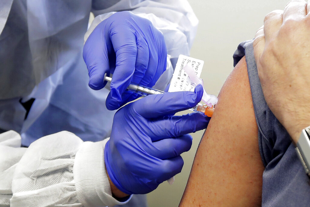 A subject receives a shot in the first-stage safety study clinical trial of a potential vaccine by Moderna for COVID-19, the disease caused by the new coronavirus, at the Kaiser Permanente Washington Health Research Institute in Seattle in March. (AP Photo/Ted S. Warren, File)