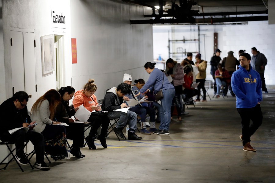 In this March 13, 2020 file photo, unionized hospitality workers wait in line in a basement garage to apply for unemployment benefits at the Hospitality Training Academy in Los Angeles. California's unemployment rate continued to climb in May, reaching 16.3% as businesses continued to lay people off because of a state-at-home order aimed at slowing the spread of the coronavirus that has wrecked the state's economy. (AP Photo/Marcio Jose Sanchez, File)