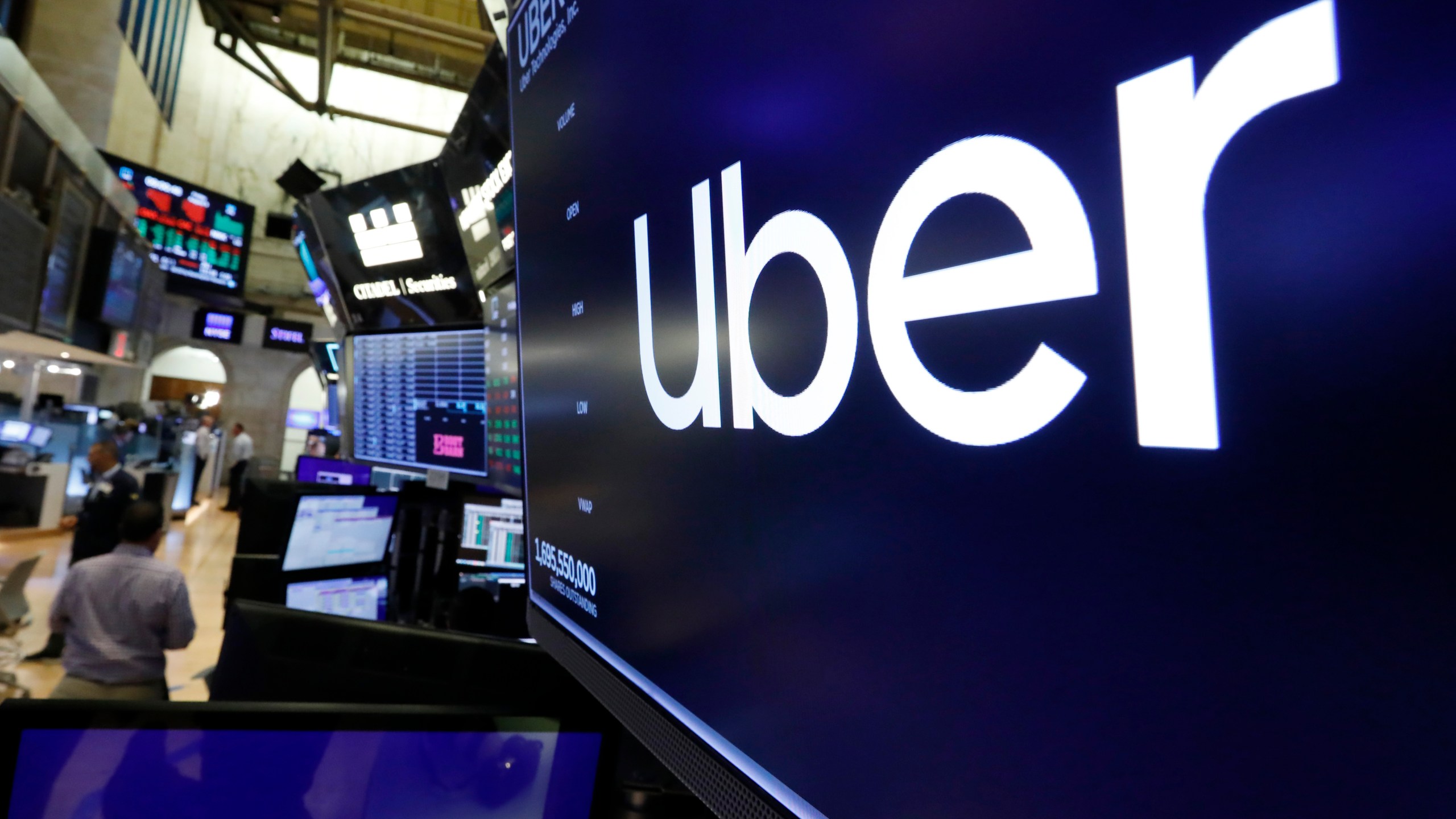 The logo for Uber appears above a trading post on the floor of the New York Stock Exchange on Aug. 9, 2019. (AP Photo/Richard Drew, File)