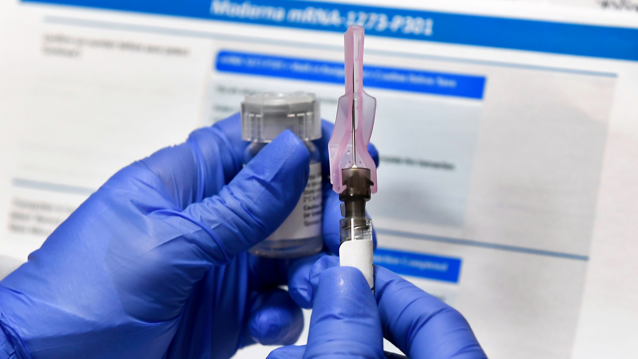 In this July 27, 2020 file photo, a nurse prepares a shot as a study of a possible COVID-19 vaccine, developed by the National Institutes of Health and Moderna Inc., gets underway in Binghamton, N.Y. Who gets to be first in line for a COVID-19 vaccine? U.S. health authorities hope by late next month to have some draft guidance on how to ration initial doses, but it’s a vexing decision. (AP Photo/Hans Pennink)