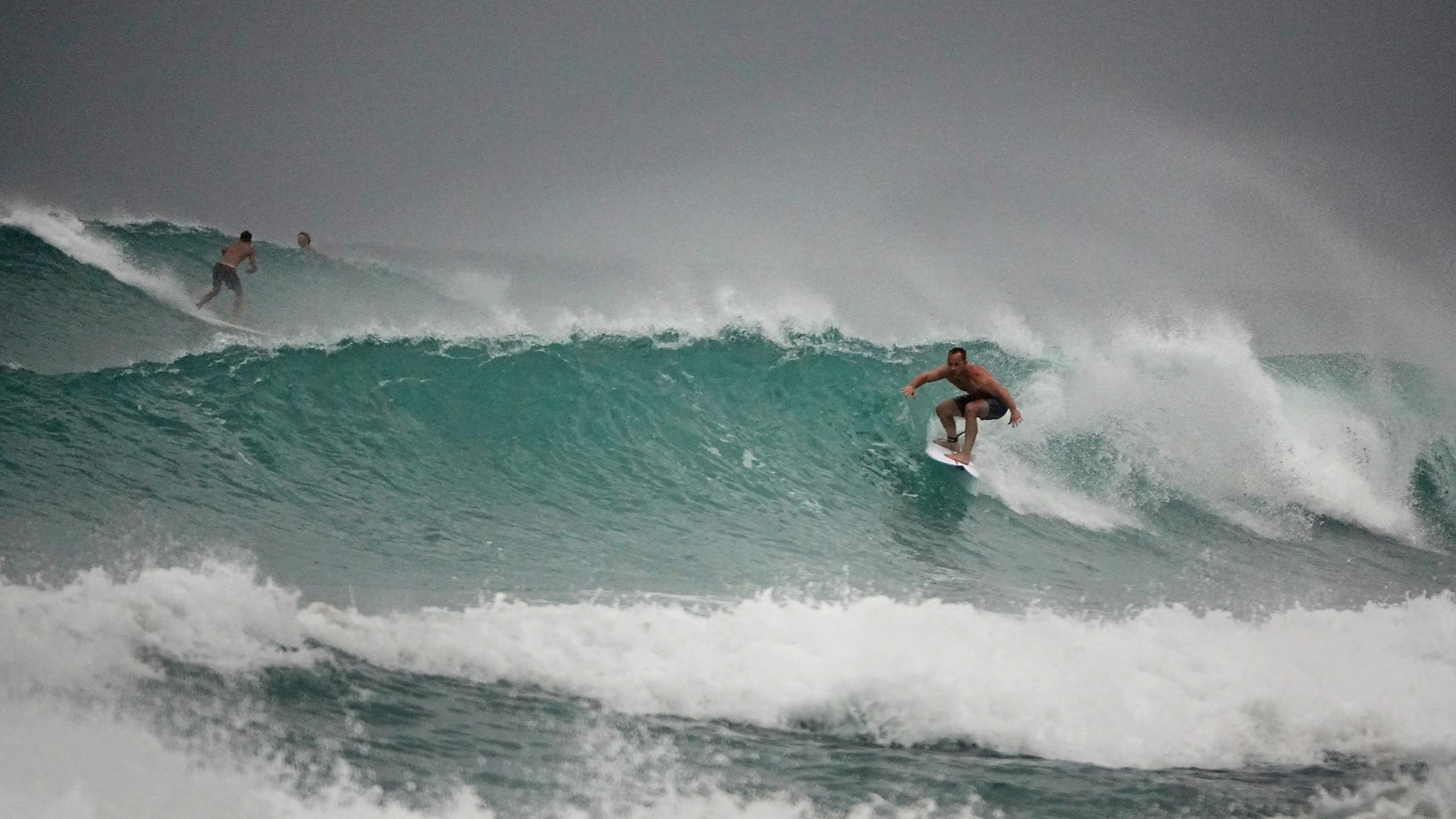 Surfers in Delray Beach enjoy the waves, Sunday, Aug. 2, 2020, as Tropical Storm Isaias brushes past the East Coast of Florida. (Joe Cavaretta/South Florida Sun-Sentinel via AP)