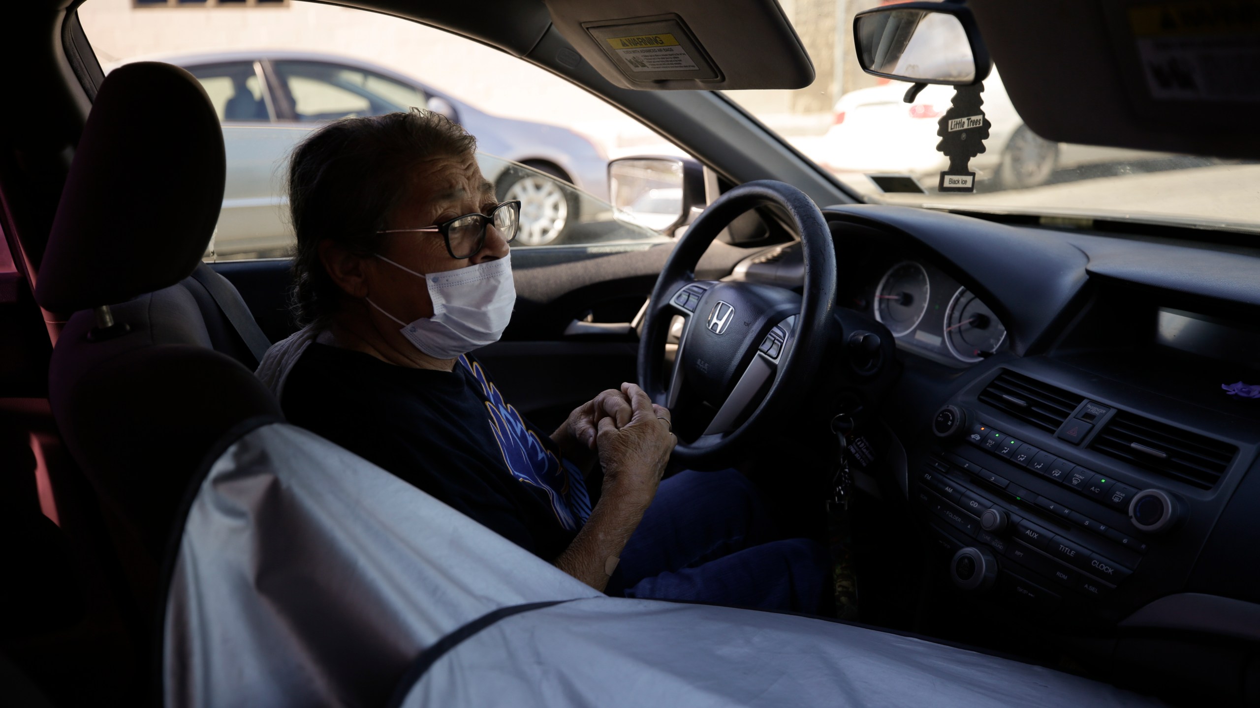 Marta Rosales waits in line for food at a distribution center Thursday, July 23, 2020, in Brawley, Calif. Rosales, who suffers from various health issues, rarely leaves her home during the coronavirus outbreak. She says the food she receives at the distribution center has been a savior. (AP Photo/Gregory Bull)