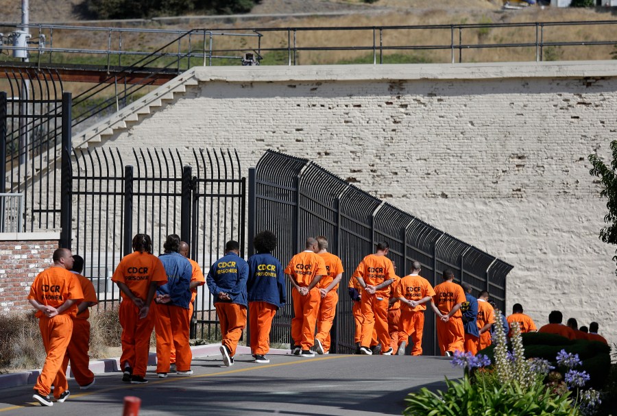 In this Aug. 16, 2016, file photo, a row of general population inmates walk in a line at San Quentin State Prison in San Quentin. (AP Photo/Eric Risberg, File)