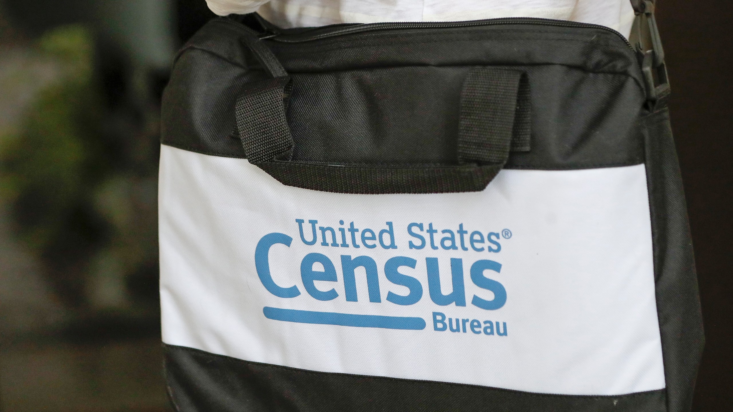 A briefcase of a census taker is seen as she knocks on the door of a residence Tuesday, Aug. 11, 2020, in Winter Park, Fla. A half-million census takers head out en mass this week to knock on the doors of households that haven't yet responded to the 2020 census. (AP Photo/John Raoux)