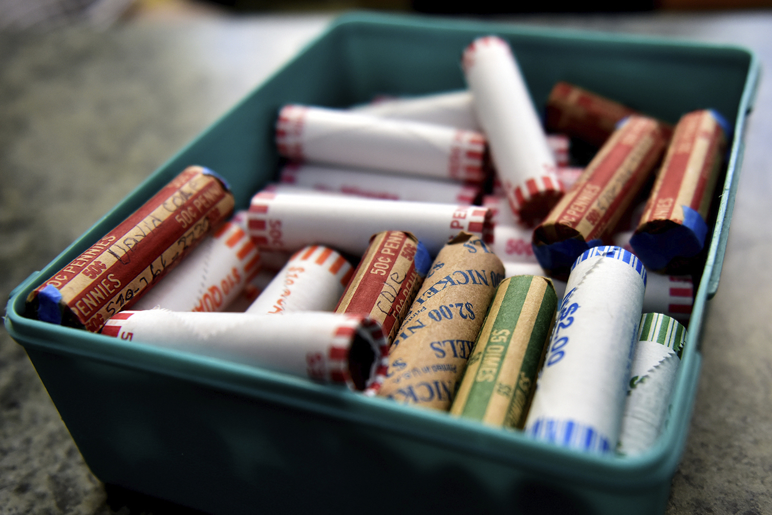 This, July 15, 2020 file photo shows rolls of coins in a container at a market in Nanticoke, Pa. The Federal Reserve says the supply system for coins had been severely disrupted by the pandemic. While there were still enough coins out in the world, they aren’t circulating as freely because businesses have been closed and consumers weren’t spending as usual. (Sean McKeag/The Citizens' Voice via AP)