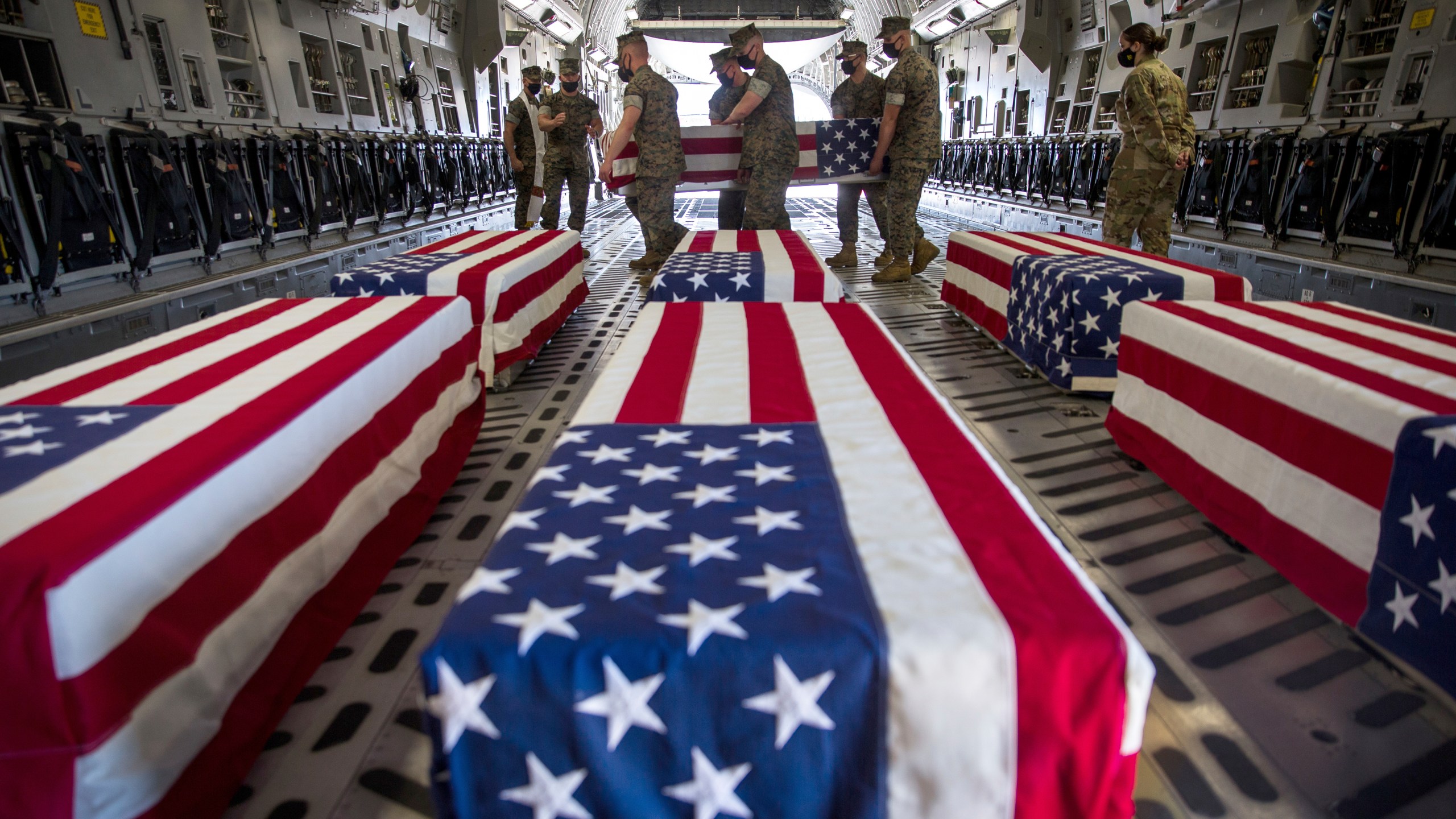 In this photo provided by the U.S. Marine Corps, U.S. Marines and sailors carry a casket inside a U.S. Air Force C-17 Globemaster III at Marine Corps Air Station Miramar, in Calif., Wednesday, Aug. 12, 2020. (Lance Cpl. Brendan Mullin/U.S. Marine Corps via AP)