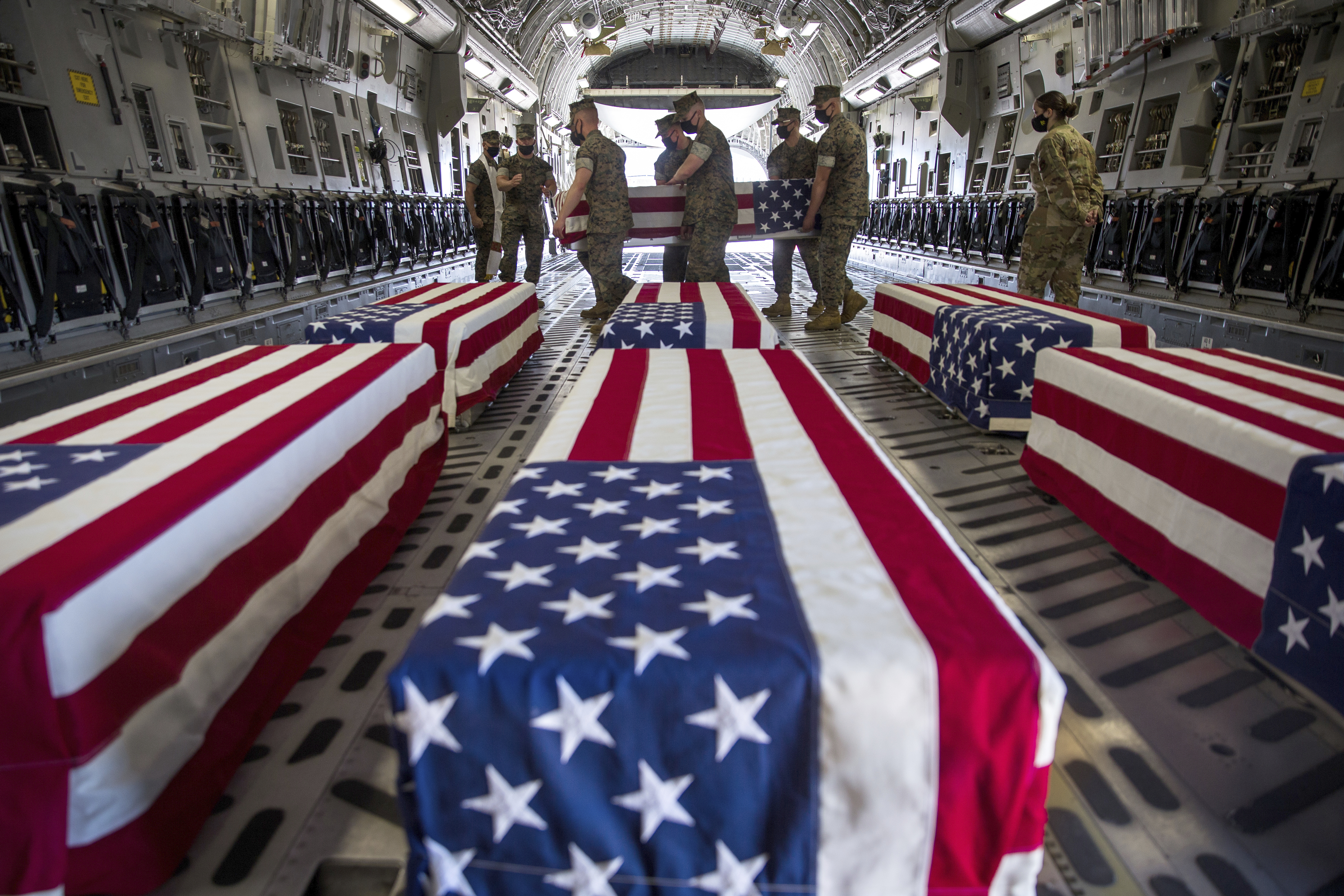 In this photo provided by the U.S. Marine Corps, U.S. Marines and sailors carry a casket inside a U.S. Air Force C-17 Globemaster III at Marine Corps Air Station Miramar, in Calif., Wednesday, Aug. 12, 2020. (Lance Cpl. Brendan Mullin/U.S. Marine Corps via AP)