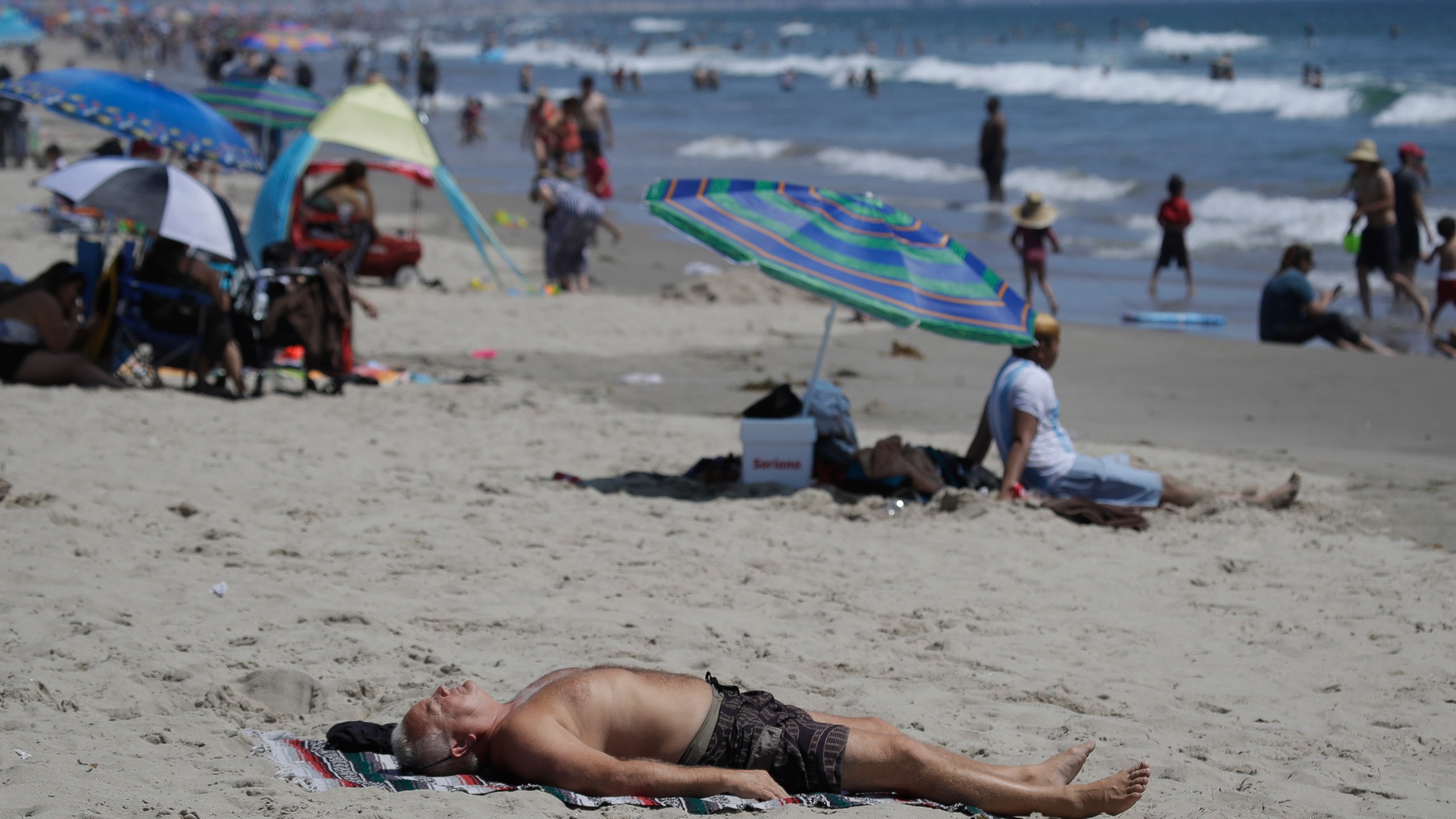 In this Sunday, July 12, 2020, file photo, a man lies on the beach amid the coronavirus pandemic in Santa Monica. (AP Photo/Marcio Jose Sanchez, File)