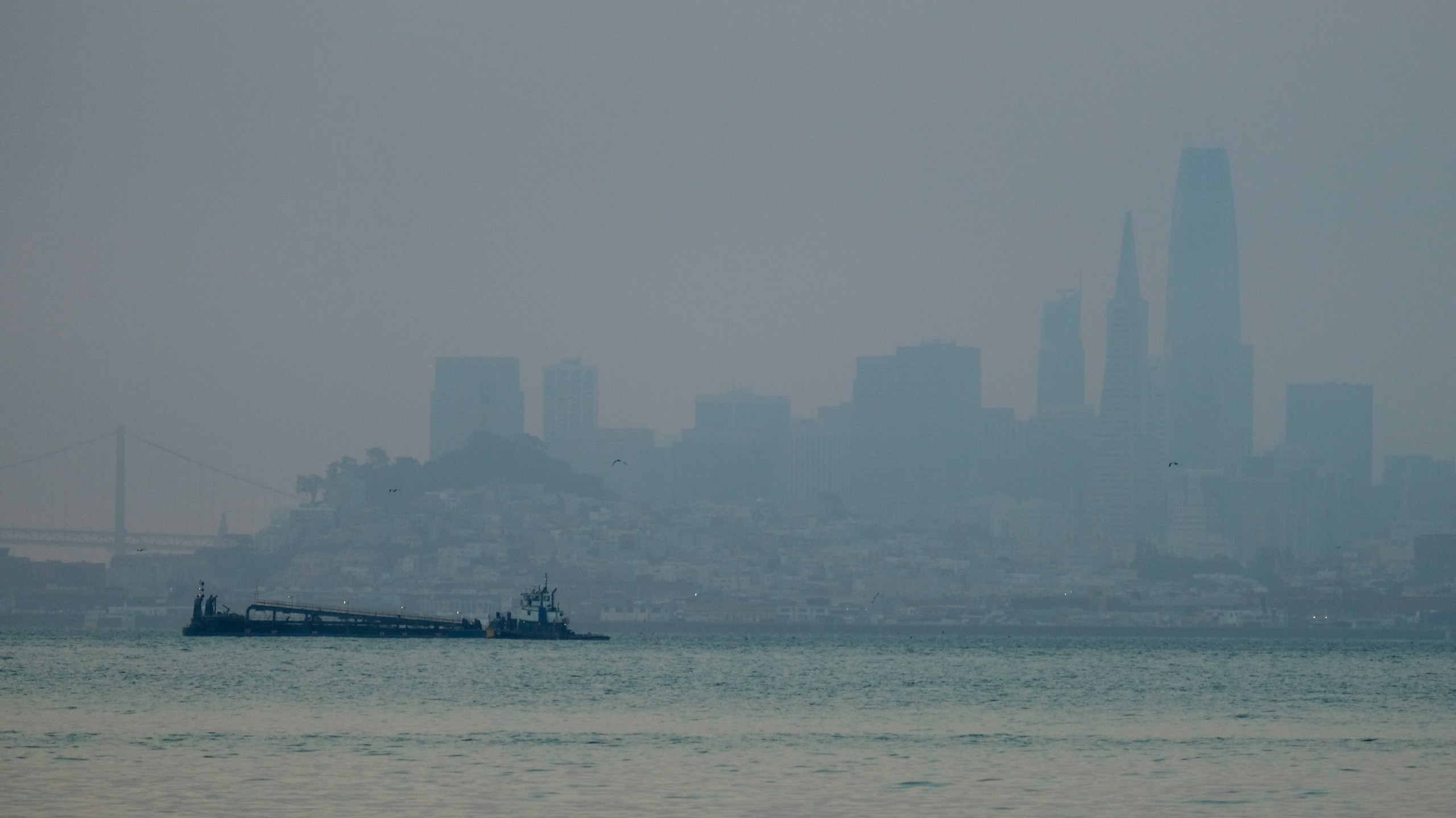 The San Francisco skyline is barely visible through smoke from wildfires Wednesday, Aug. 19, 2020, in this view from Sausalito, Calif. Thousands of people were under orders to evacuate in regions surrounding the San Francisco Bay Area Wednesday as nearly 40 wildfires blazed across the state amid a blistering heat wave now in its second week. Smoke blanketed the city of San Francisco. (AP Photo/Eric Risberg)