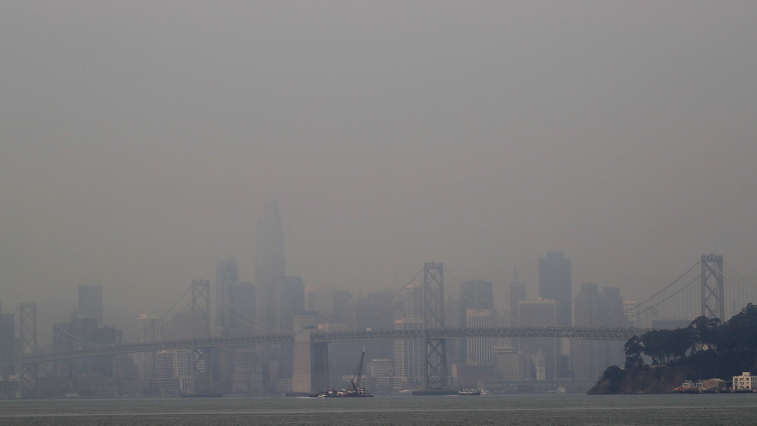 Smoke from wildfires obscures a view of the San Francisco skyline and the San Francisco-Oakland Bay Bridge on Wednesday, Aug. 19, 2020, as seen from Oakland, Calif. Crews were battling wildfires in the San Francisco Bay Area and thousands of people were under orders to evacuate Wednesday as hundreds of wildfires blazed across the state amid a blistering heat wave now in its second week. (AP Photo/Ben Margot)