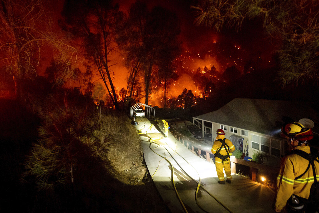 Firefighters protect a home in the Berryessa Estates neighborhood of unincorporated Napa County, Calif., as the LNU Lightning Complex fires burn on Aug. 21, 2020. (AP Photo/Noah Berger)