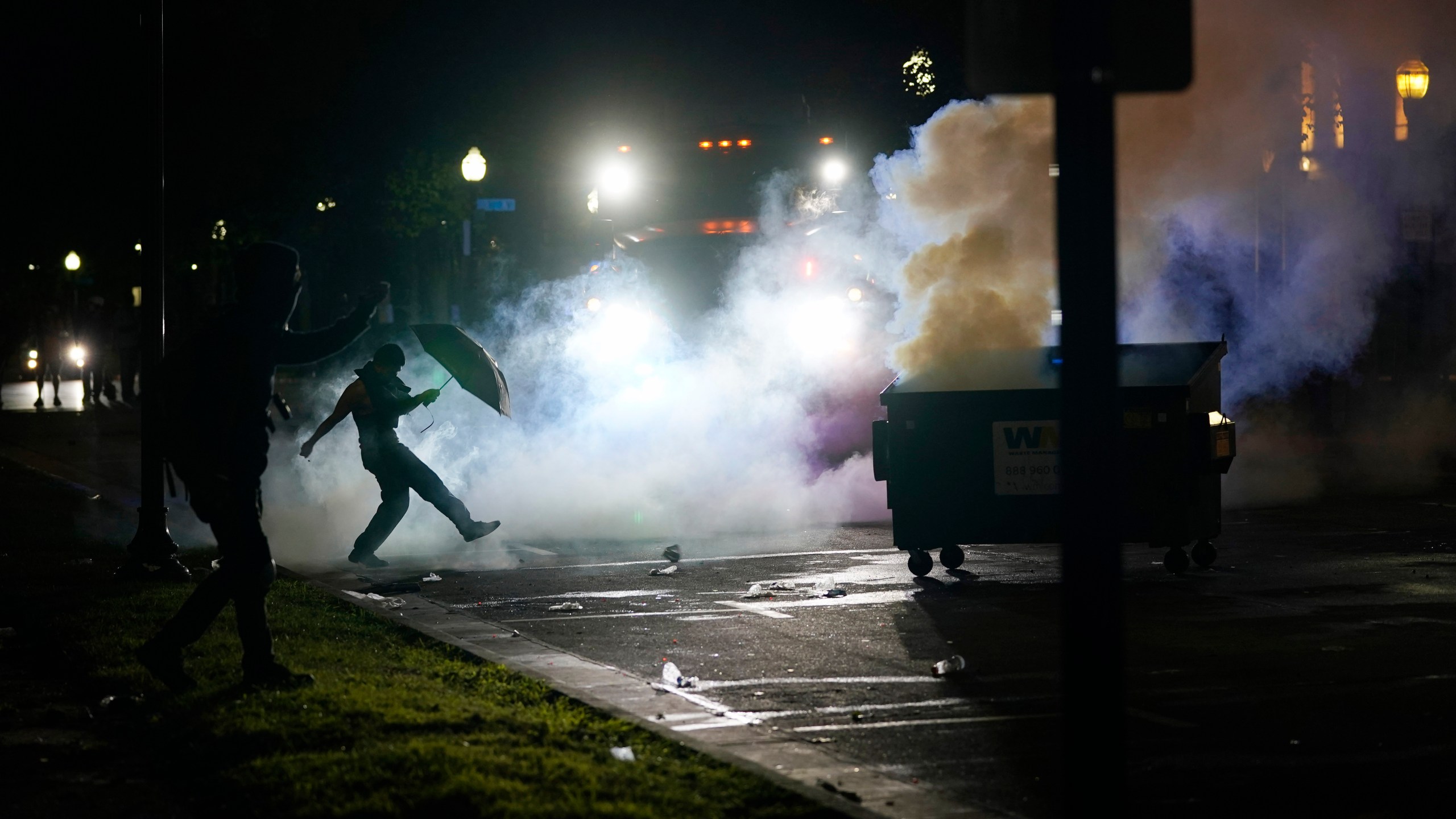 A protester kicks a smoke canister Tuesday, Aug. 25, 2020 in Kenosha, Wis. Anger over the Sunday shooting of Jacob Blake, a Black man, by police spilled into the streets for a third night. (AP Photo/Morry Gash)