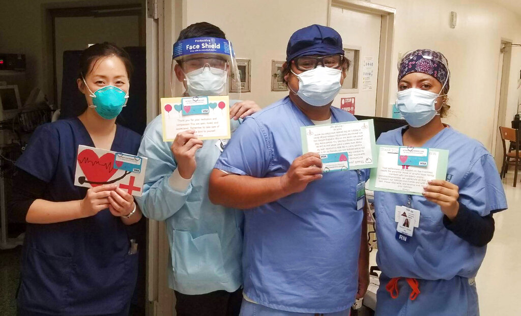 In this June 30, 2020, photo provided by Keith Levy, health care workers hold thank-you cards at Los Angeles Community Hospital in Los Angeles. Siblings Mantej Singh Lamba, 17, and Prabhleen Singh Lamba, 15, started the Cards 4 Covid Heroes initiative in May and have since delivered more than 250 cards to hospitals in California and Arizona. (Keith Levy via AP)