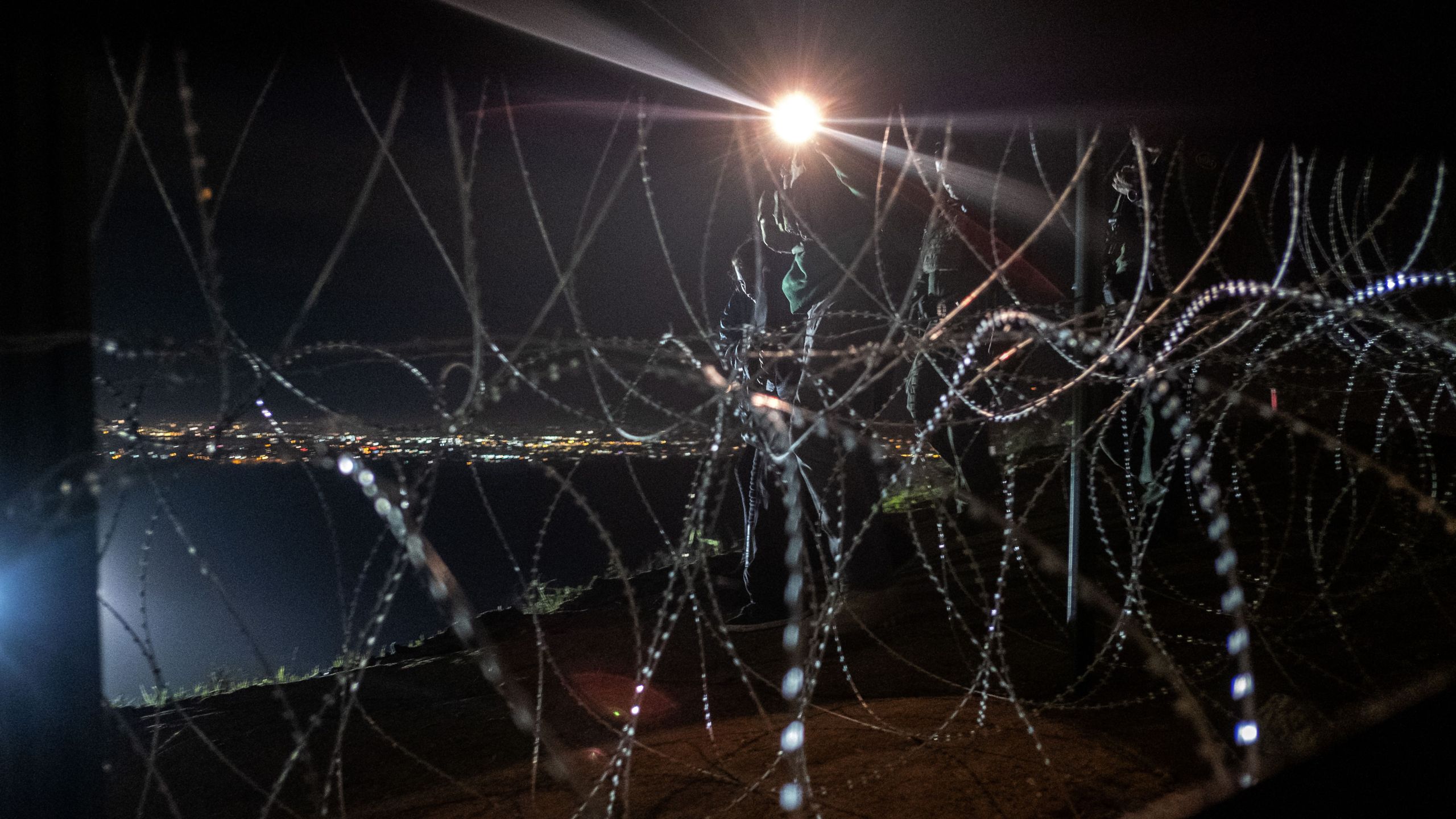 U.S. Border Patrol agents walk as they arrest a group of Central American migrants after crossing the US-Mexico border fence from Tijuana to San Diego County as seen from Tijuana, Baja California State, Mexico, on December 26, 2018. (GUILLERMO ARIAS/AFP via Getty Images)