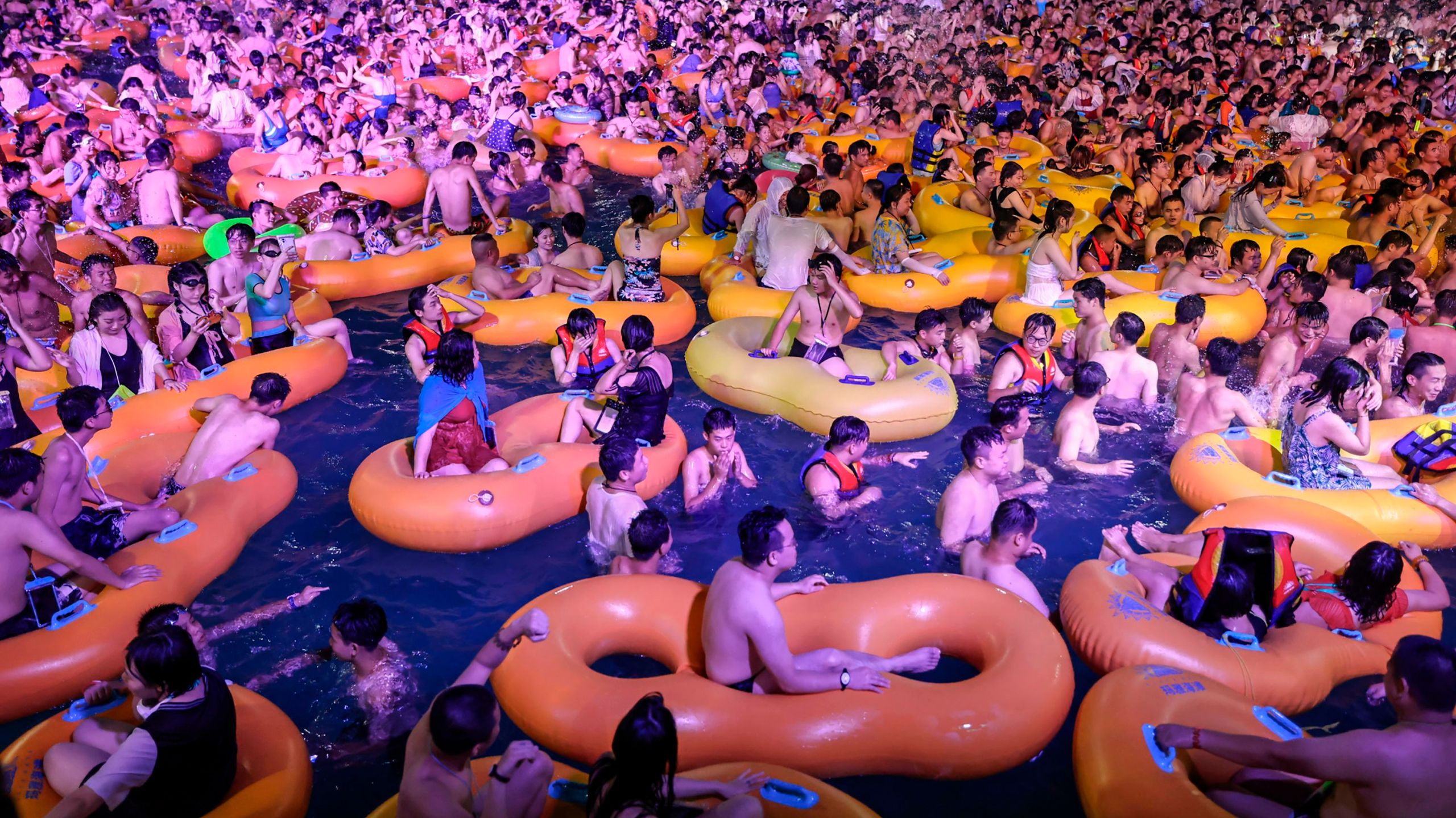 This photo taken on August 15, 2020, shows people watching a performance as they cool off in a swimming pool in Wuhan in China's central Hubei province. (STR/AFP via Getty Images)