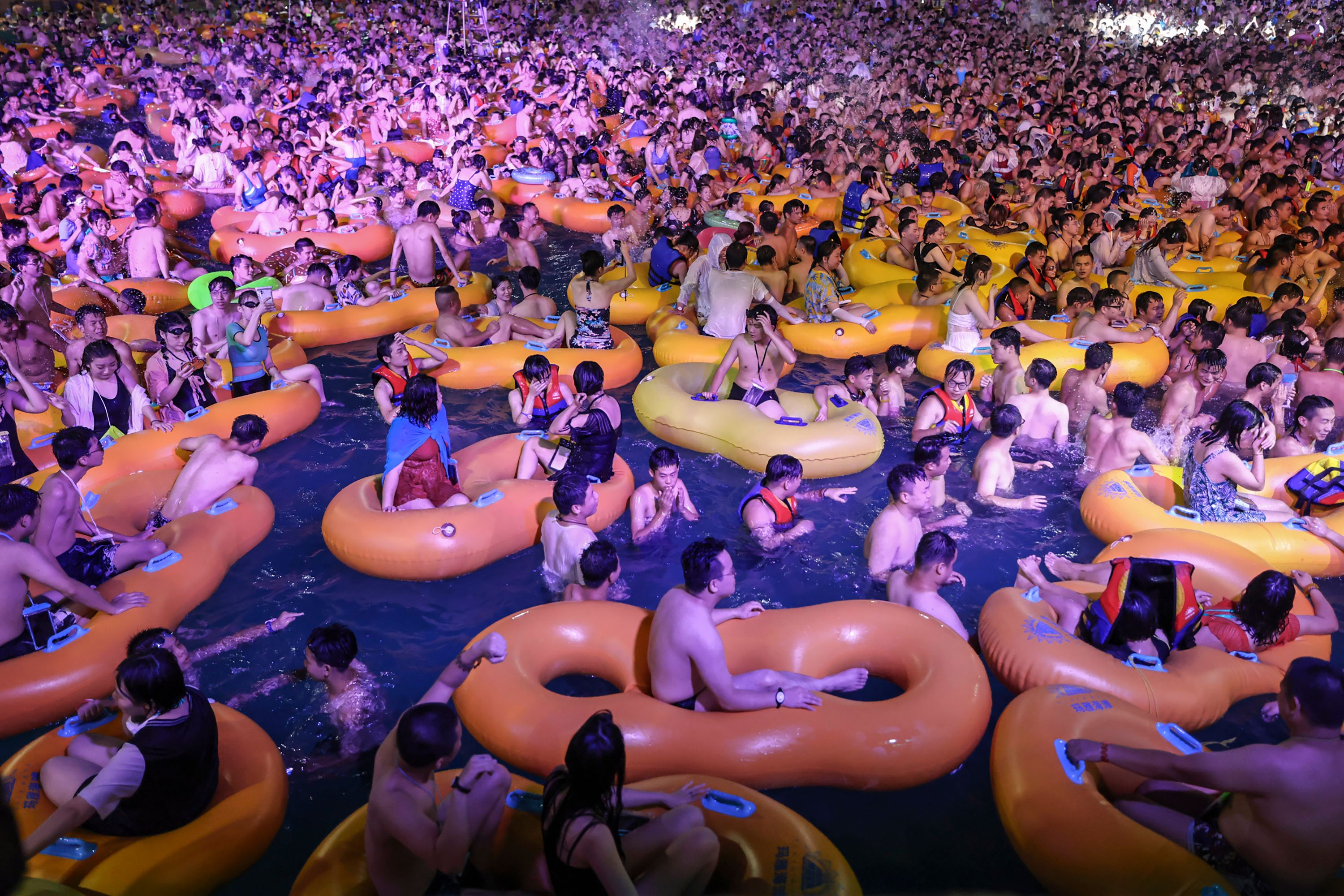 This photo taken on August 15, 2020, shows people watching a performance as they cool off in a swimming pool in Wuhan in China's central Hubei province. (STR/AFP via Getty Images)