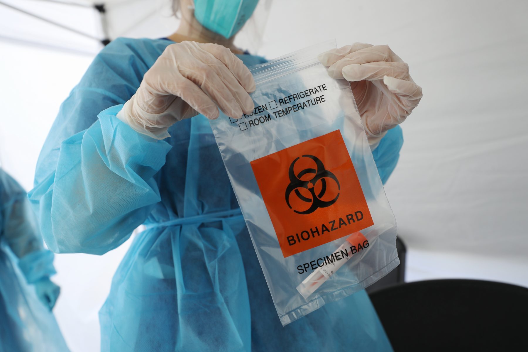 A nurse seals a specimen bag containing a COVID-19 test swab at a St. John’s Well Child & Family Center mobile clinic set up outside Walker Temple AME Church in South Los Angeles amid the coronavirus pandemic on July 15, 2020 in Los Angeles, California. (Mario Tama/Getty Images)