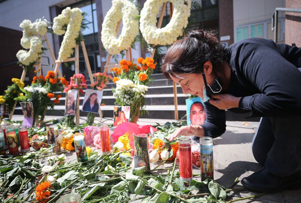 Elda Martinez, with the L.A. County Federation of Labor, blows out a candle at a public memorial honoring the 5,700 Los Angeles County residents who have died due to COVID-19 on Aug. 31, 2020 in downtown Los Angeles. (Mario Tama/Getty Images)