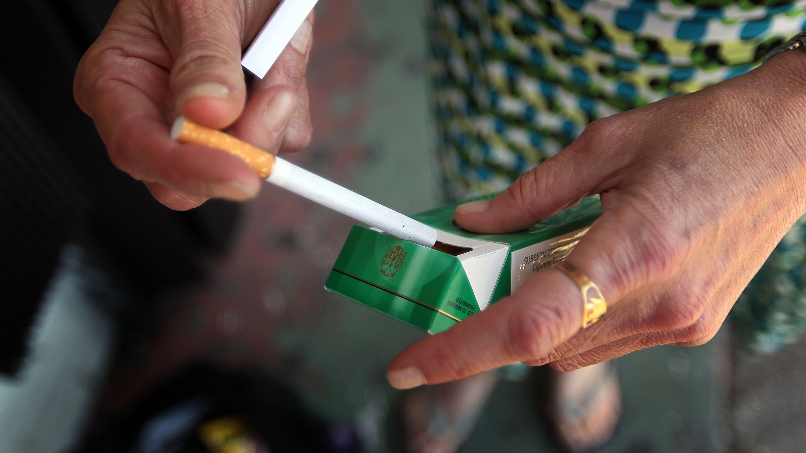 A woman pulls out a menthol cigarette in front of a Quick Stop store on March 30, 2010, in Miami, Florida. (Joe Raedle/Getty Images)