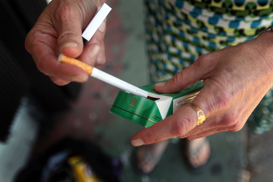 A woman pulls out a menthol cigarette in front of a Quick Stop store on March 30, 2010, in Miami, Florida. (Joe Raedle/Getty Images)