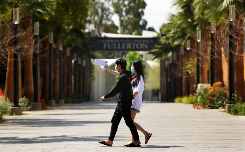 Cal State Fullerton student Linh Trinh, 21, right, and boyfriend Tan Nguyen, 21, walk around the deserted campus in April 2020. (Christina House / Los Angeles Times)