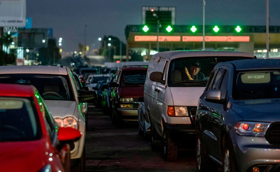 Commuters line up while waiting for the Otay Mesa Port of Entry to open to cross to the United States from Tijuana, Baja California state, Mexico, on early May 20, 2020. (GUILLERMO ARIAS/AFP via Getty Images)