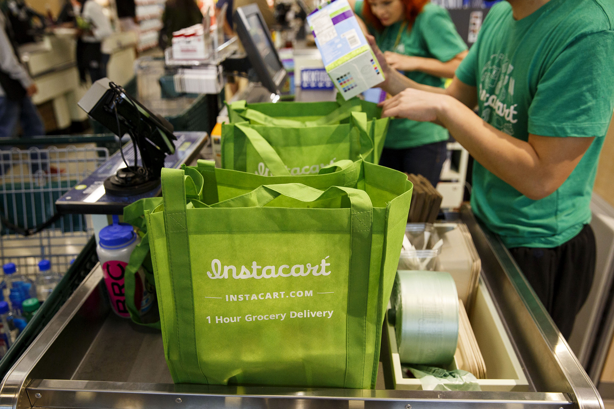 InstaCart employees fulfill orders for delivery at a Whole Foods Market Inc. store in downtown Los Angeles on Nov. 9, 2015. (Patrick T. Fallon/Bloomberg via Getty Images via CNN)