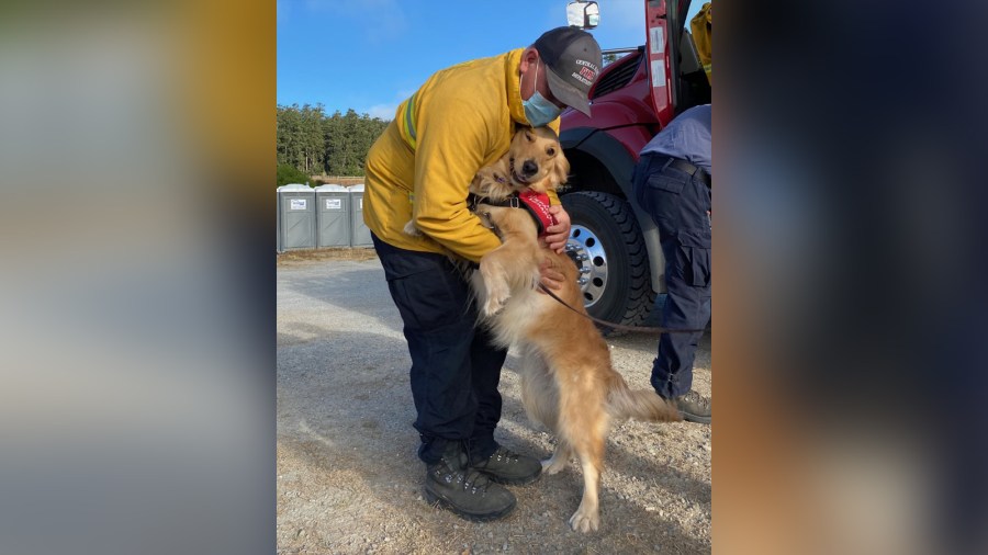 Kerith hugs a firefighter at the staging area of the Woodward Fire in 2020. (Heidi Carmen via CNN)