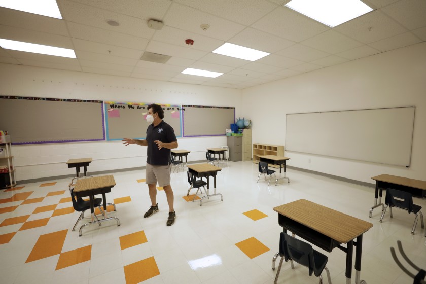 Xavier Reyes, cofounder of Alta Public Schools, shows what a classroom would look like at Academia Moderna, a charter school, when the Huntington Park campus is allowed to reopen. (Myung J. Chun / Los Angeles Times)