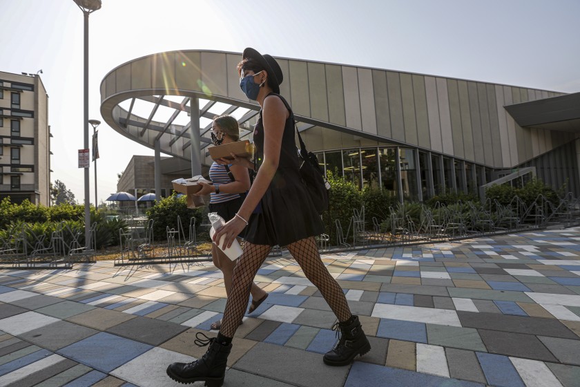 Students walk back to their dorms from the Cal State Fullerton dining facility a few days before the start of classes in August 2020. (Irfan Khan / Los Angeles Times)