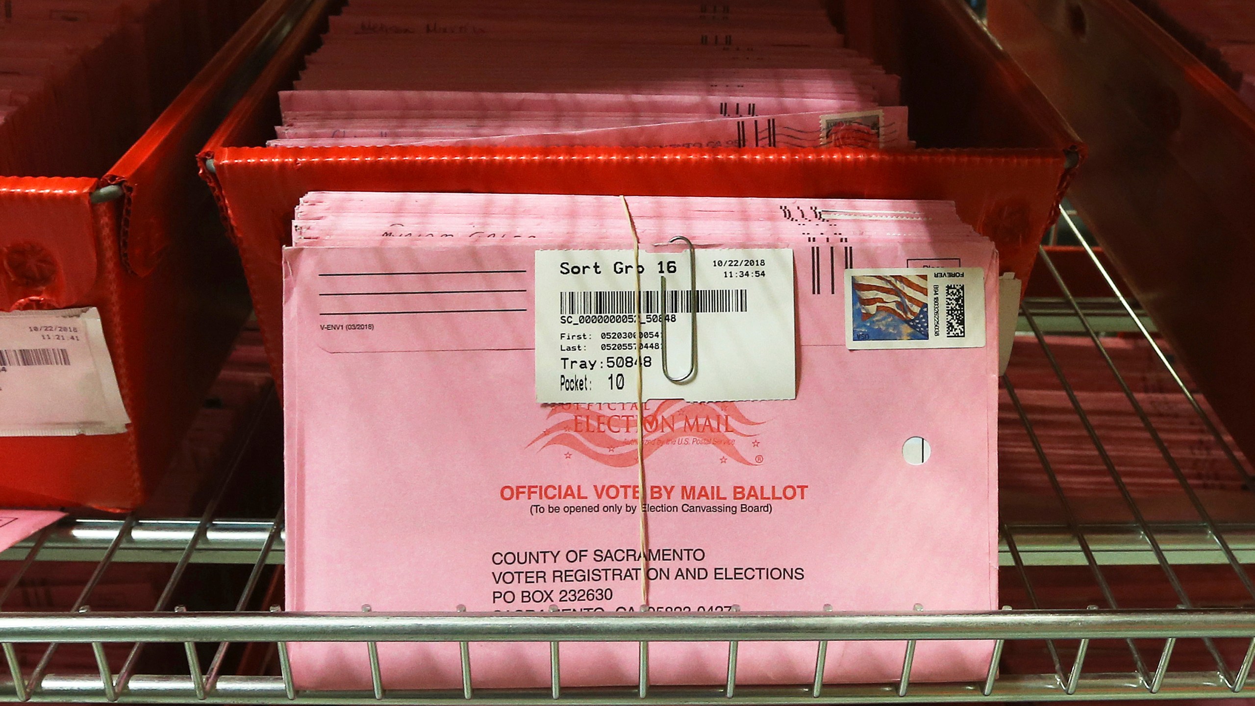 Mail-in ballots are placed in bins to be processed after arriving at the Sacramento County Registrar of Voters in Sacramento on Oct. 22, 2018. (Rich Pedroncelli / Associated Press)