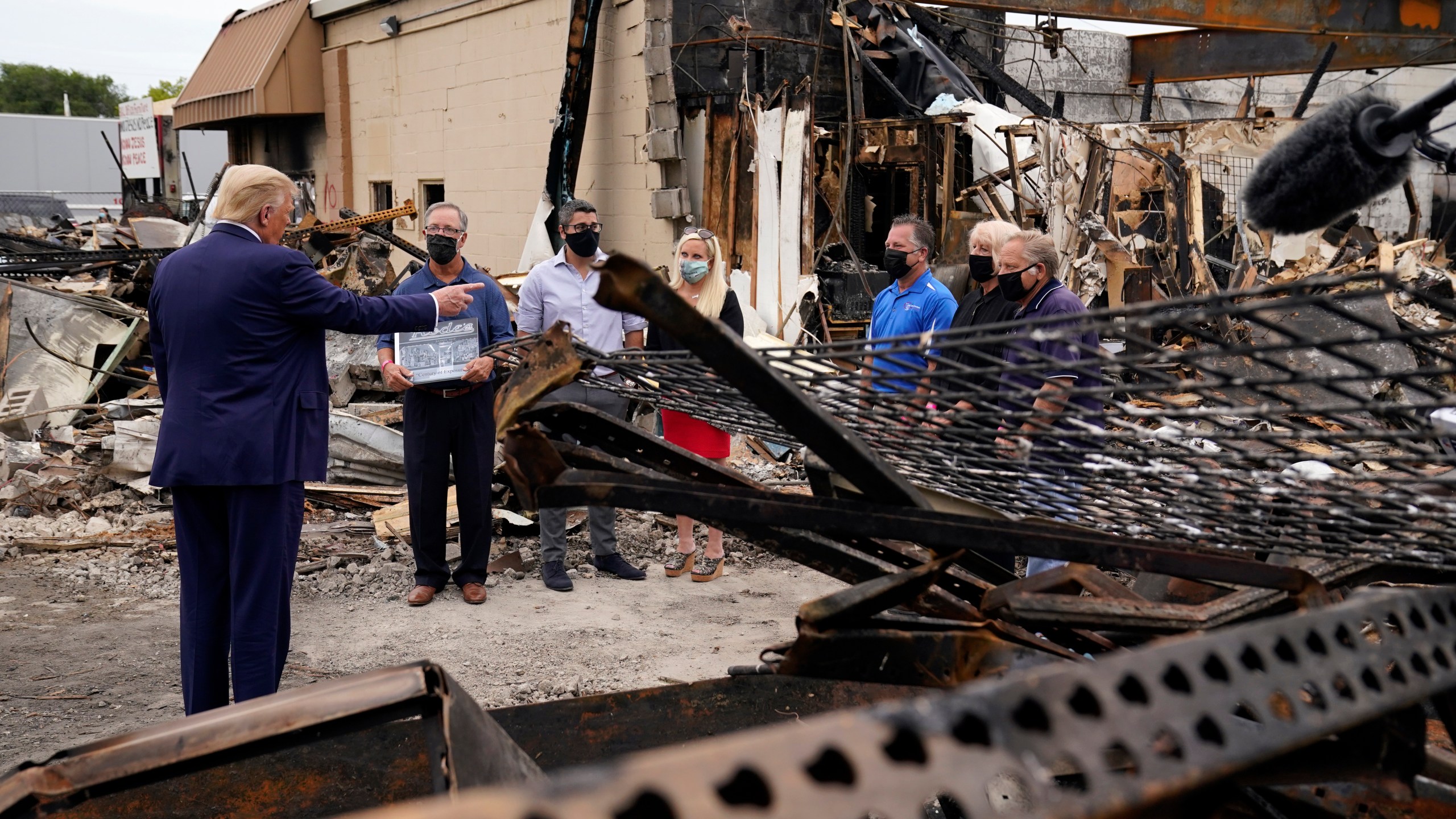 President Donald Trump talks to business owners Tuesday, Sept. 1, 2020, as he tours an area damaged during demonstrations after a police officer shot Jacob Blake in Kenosha, Wis. (AP Photo/Evan Vucci)