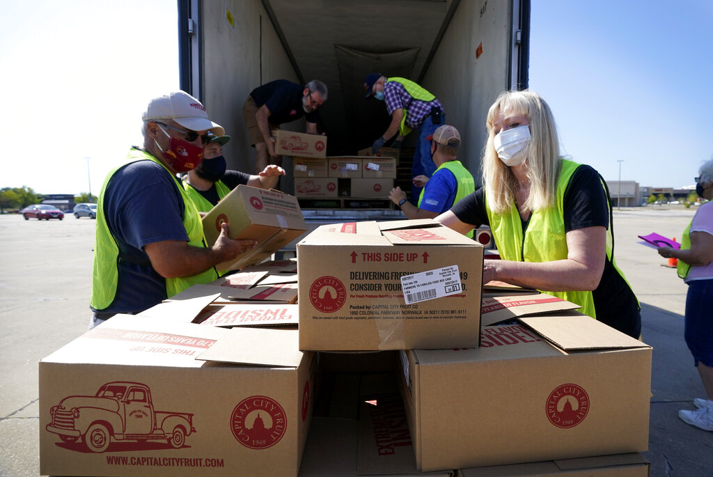 Volunteers load a pallet during a drive-up produce giveaway organized by a Des Moines food pantry, Friday, Aug. 28, 2020, in Des Moines, Iowa. (AP Photo/Charlie Neibergall)