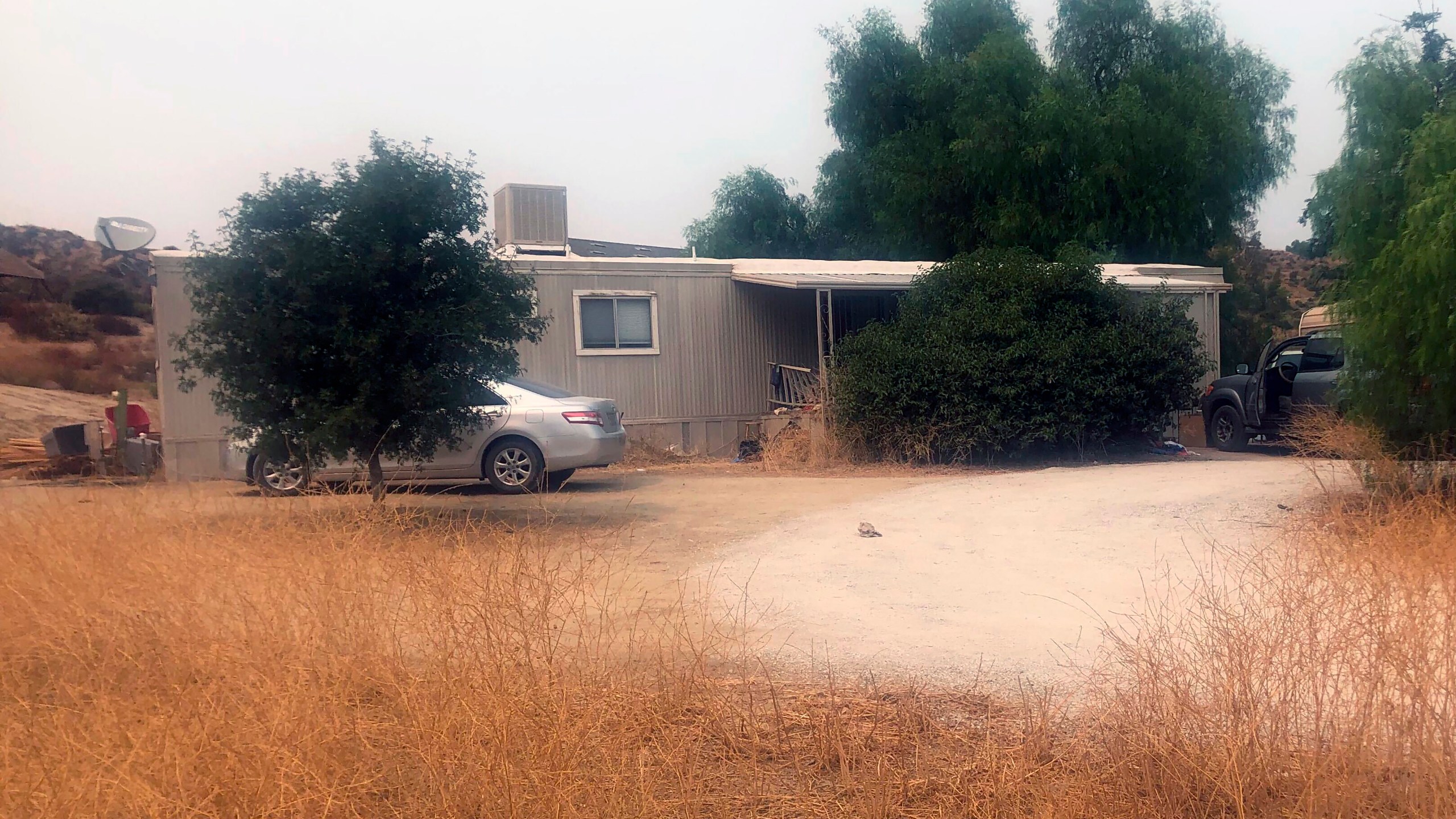 A car is left parked at a house where killings occurred in the rural town Aguanga, Calif., Tuesday, Sept. 8, 2020. Seven people were found fatally shot at an illegal marijuana growing operation in Aguanga. The crime scene was discovered before dawn Monday, Sept. 7, after deputies responded to a report of an assault with a deadly weapon at a home in the unincorporated community of Aguanga, north of San Diego, the Riverside County Sheriff's Department said in a statement. (AP Photo/Elliot Spagat)