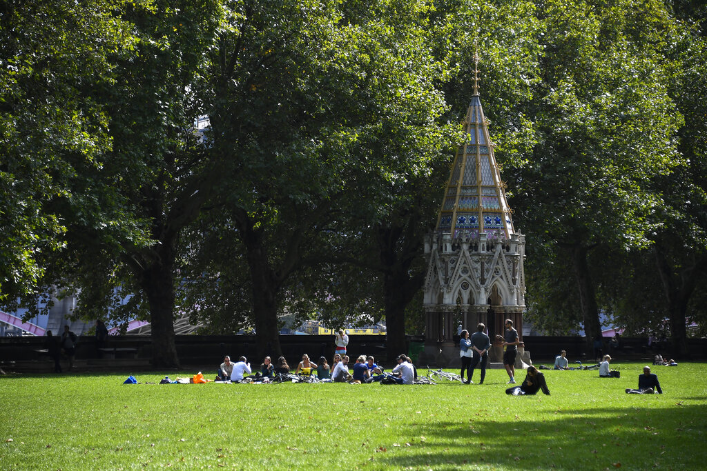 People sit on the grass at Victoria Gardens, in London, Thursday, Sept. 10, 2020. (AP Photo/Alberto Pezzali)