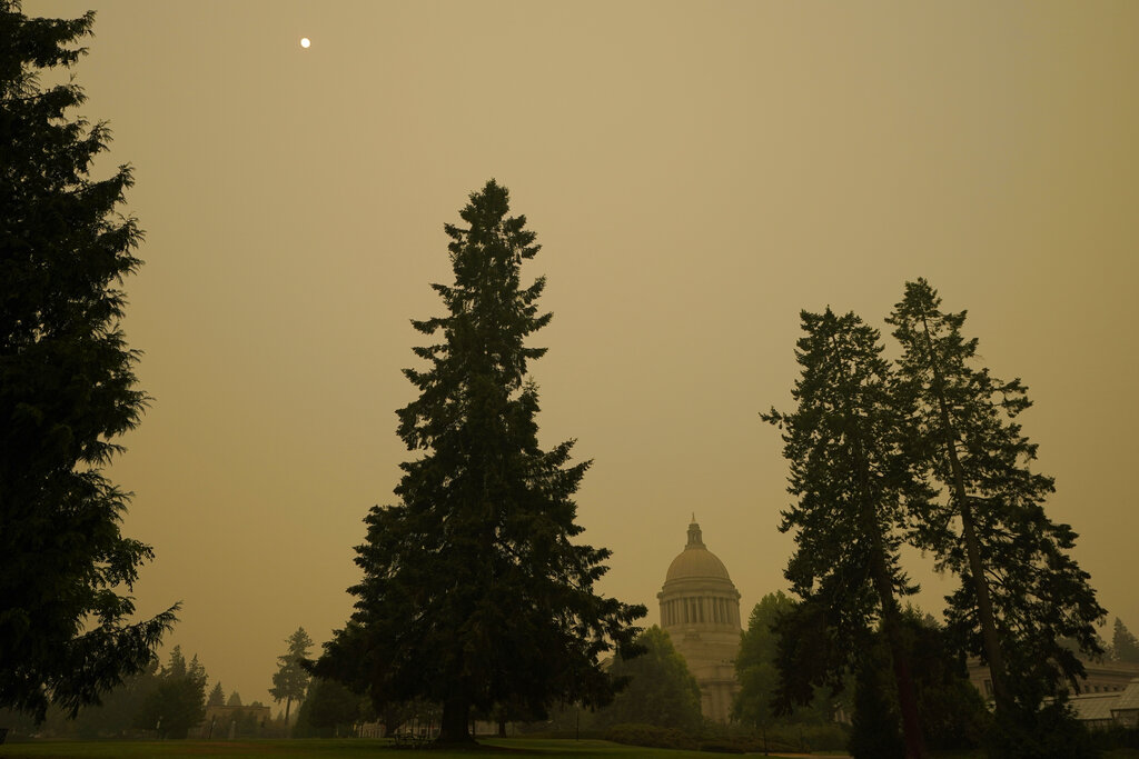 Smoke from wildfires in Oregon and California creates hazy skies as the sun is seen above the Washington state Capitol, Saturday afternoon, Sept. 12, 2020, in Olympia, Wash. (AP Photo/Ted S. Warren)