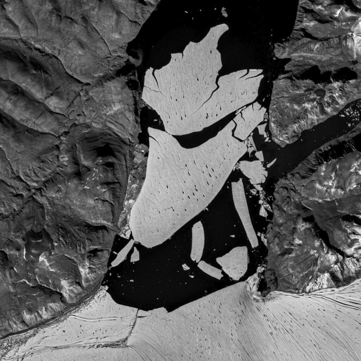 In this image provided by the European Space Agency, ESA, showing the glacier section that broke off the fjord called Nioghalvfjerdsfjorden, bottom, which is roughly 80 kilometers (50 miles) long and 20 kilometers (12 miles) wide, the National Geological Survey of Denmark and Greenland said Monday Sept. 14, 2020. The glacier is at the end of the Northeast Greenland Ice Stream, where it flows off land and into the ocean. Scientists with National Geological Survey see it as evidence of rapid climate change leading to the disintegration of the Arctic's largest remaining ice shelf. (European Space Agency via AP)