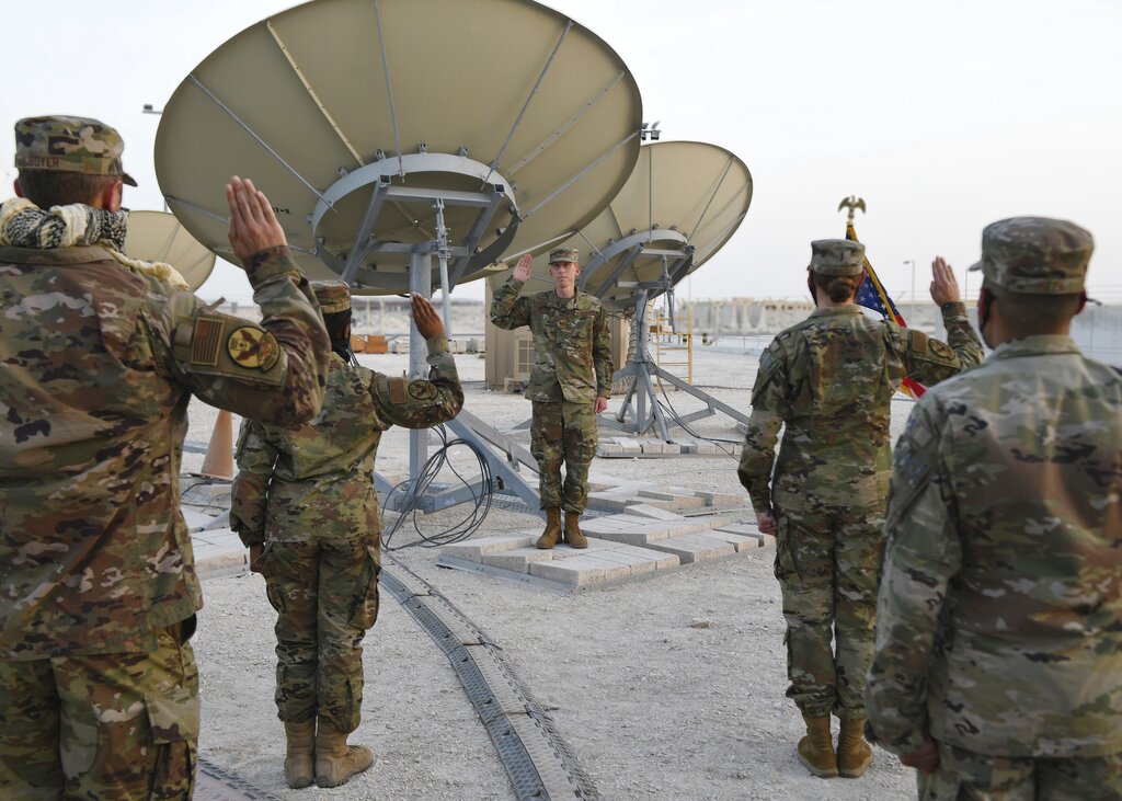 In this photo released by the U.S. Air Force, Col. Todd Benson, the U.S. Air Force Central Command director of space forces, center, leads airmen through their enlistment ceremony as they became members of the Space Force at Al-Udeid Air Base, Qatar, Tuesday, Sept. 1, 2020. (Staff Sgt. Kayla White/U.S. Air Force via AP)