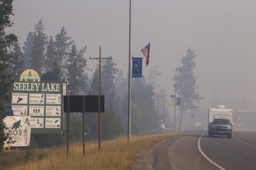 In this Aug. 10, 2017, file photo provided by the U.S. Forest Service, a pickup truck pulls a camper through the wildfire smoke in Seeley Lake in Missoula County, Montana. The small town was blanketed with hazardous smoke due to wildfires for seven weeks in 2017. (Kari Greer, U.S. Forest Service via AP, File)