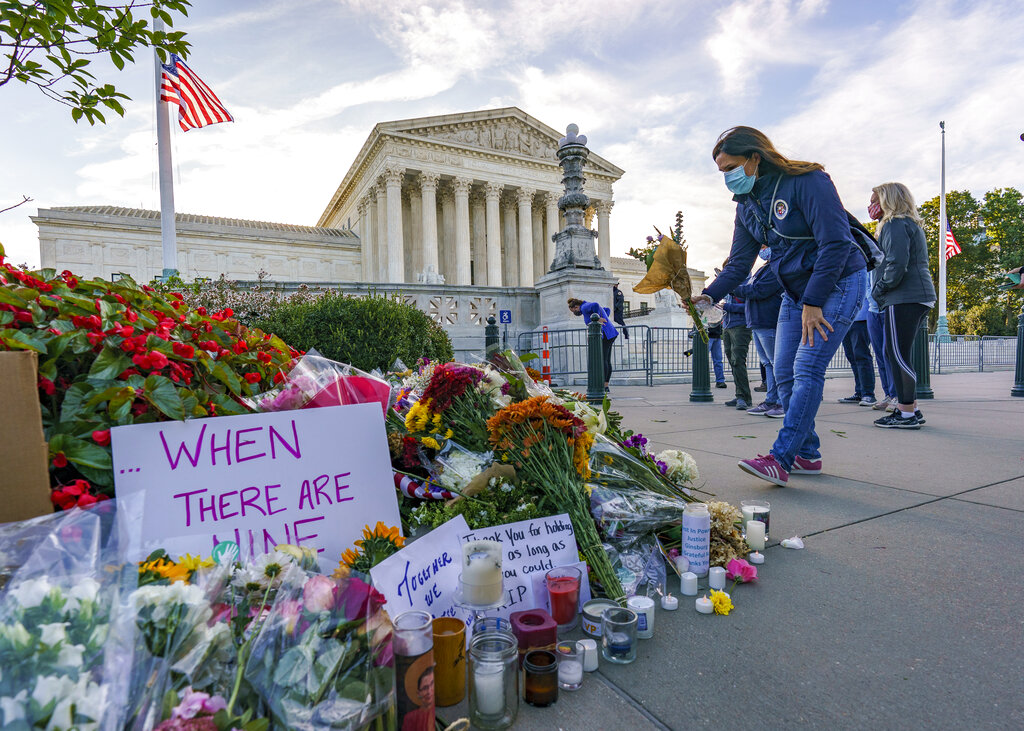 People gather at the Supreme Court on the morning after the death of Justice Ruth Bader Ginsburg, 87, Saturday, Sept. 19, 2020 in Washington. (AP Photo/J. Scott Applewhite)