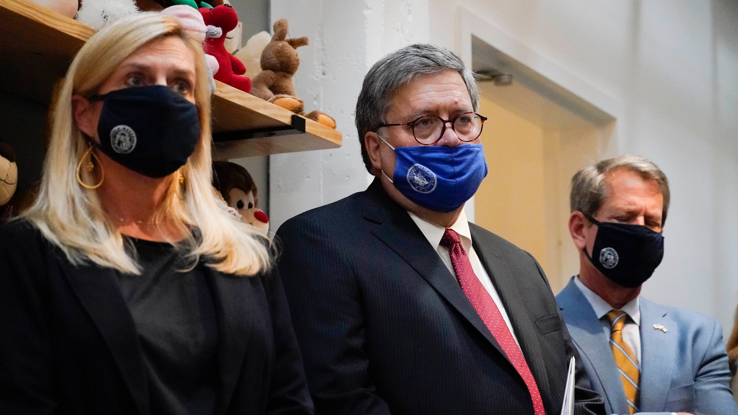 U.S. Attorney General William Barr, center, Georgia Gov. Brian Kemp, right and a Georgia Center for Child Advocacy staff member listen during a tour on Monday, Sept. 21, 2020, in Atlanta. (AP Photo/Brynn Anderson)