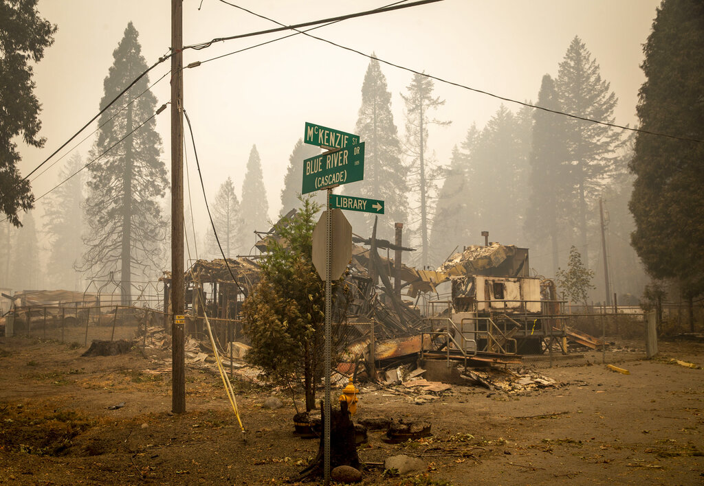 In this Sept. 15, 2020, file photo, scorched property stands at an intersection in Blue River, Ore., days after a blaze known as the Holiday Farm Fire swept through the area's business district. (Andy Nelson/The Register-Guard via AP, Pool, File)