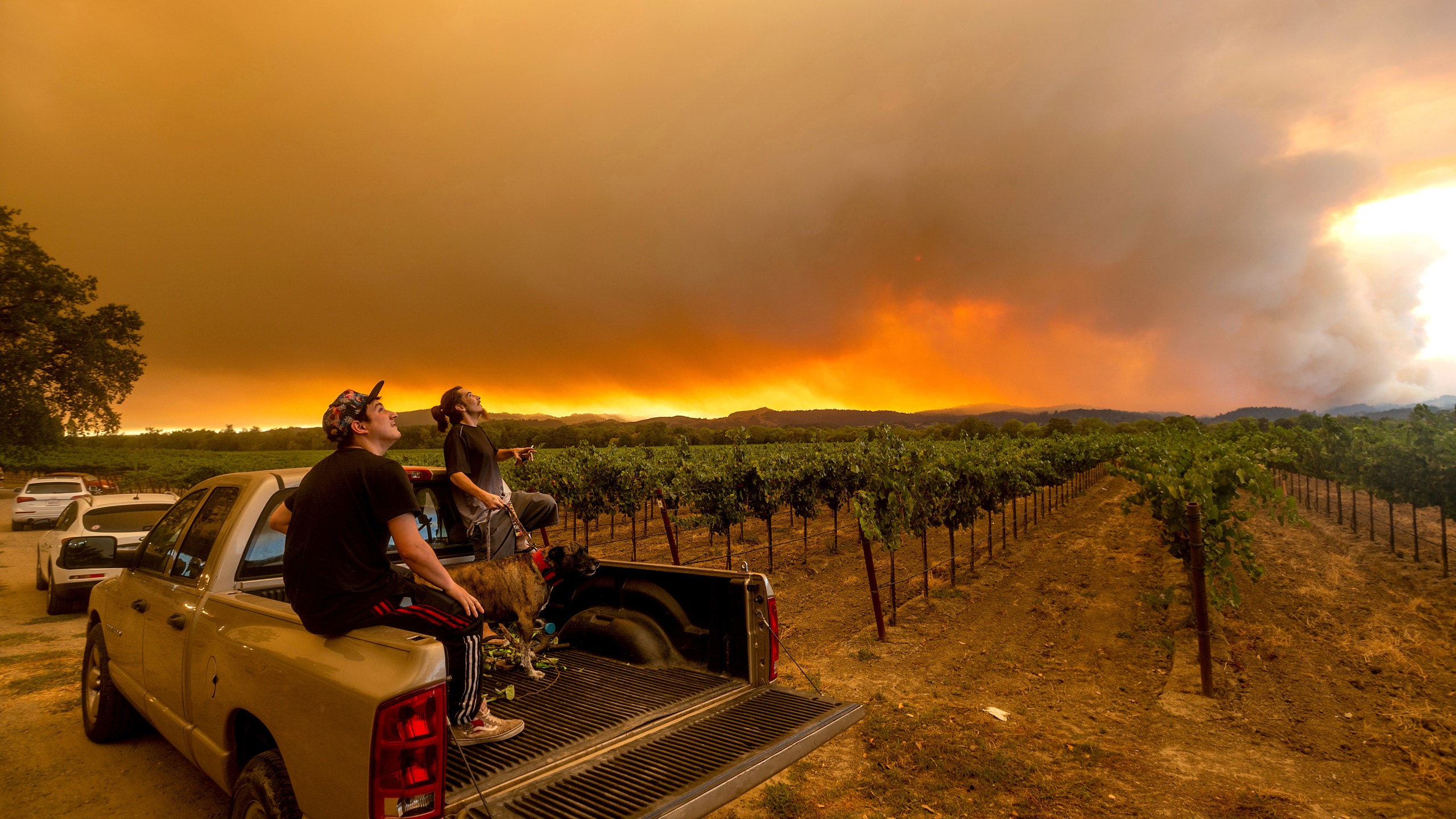 In this Aug. 20, 2020, photo, Thomas Henney, right, and Charles Chavira watch a plume spread over Healdsburg, Calif., as the LNU Lightning Complex fires burn. (AP Photo/Noah Berger, File)