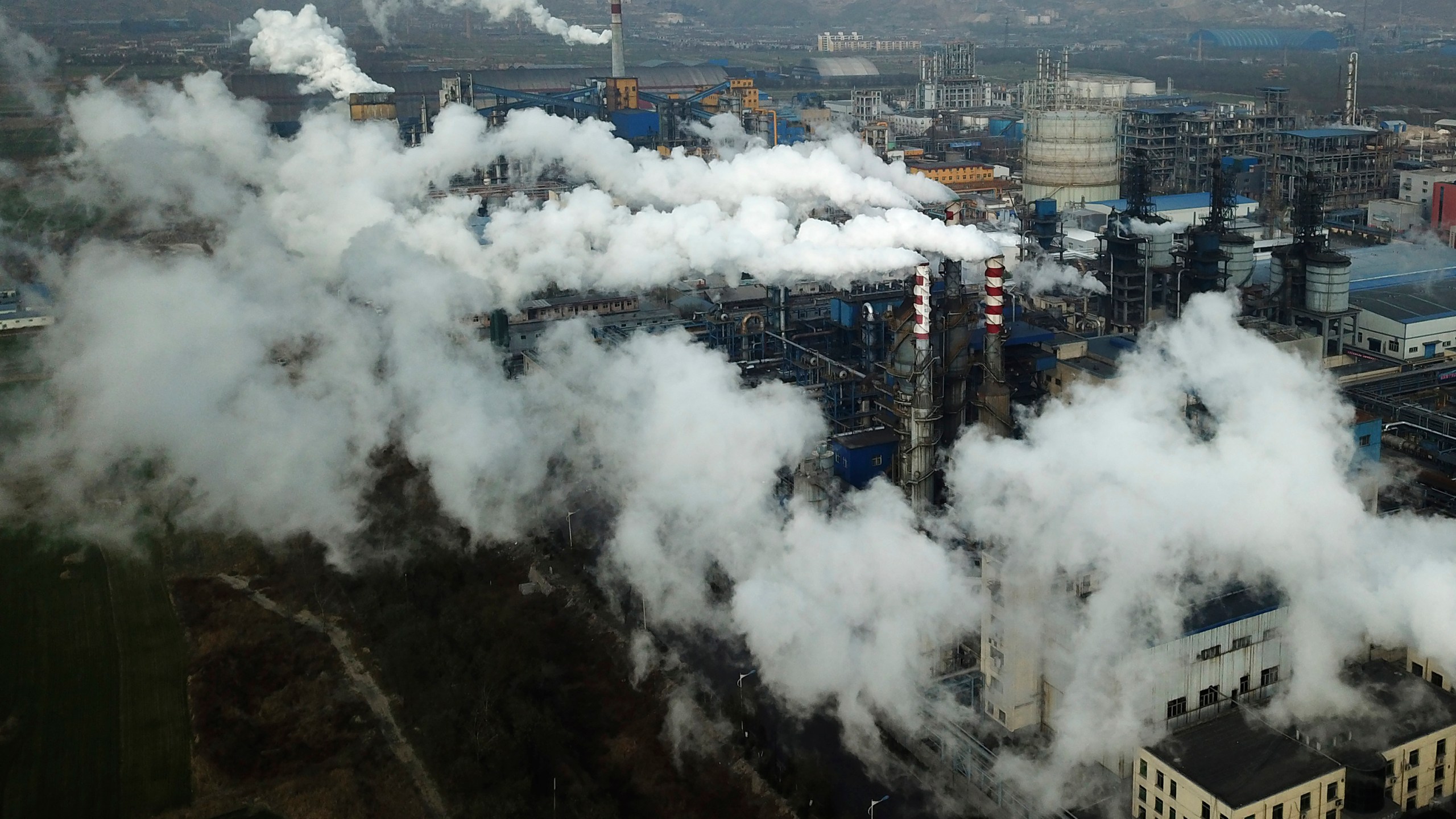 In this Nov. 28, 2019, photo, smoke and steam rise from a coal processing plant in Hejin in central China's Shanxi Province. (AP Photo/Sam McNeil, File)