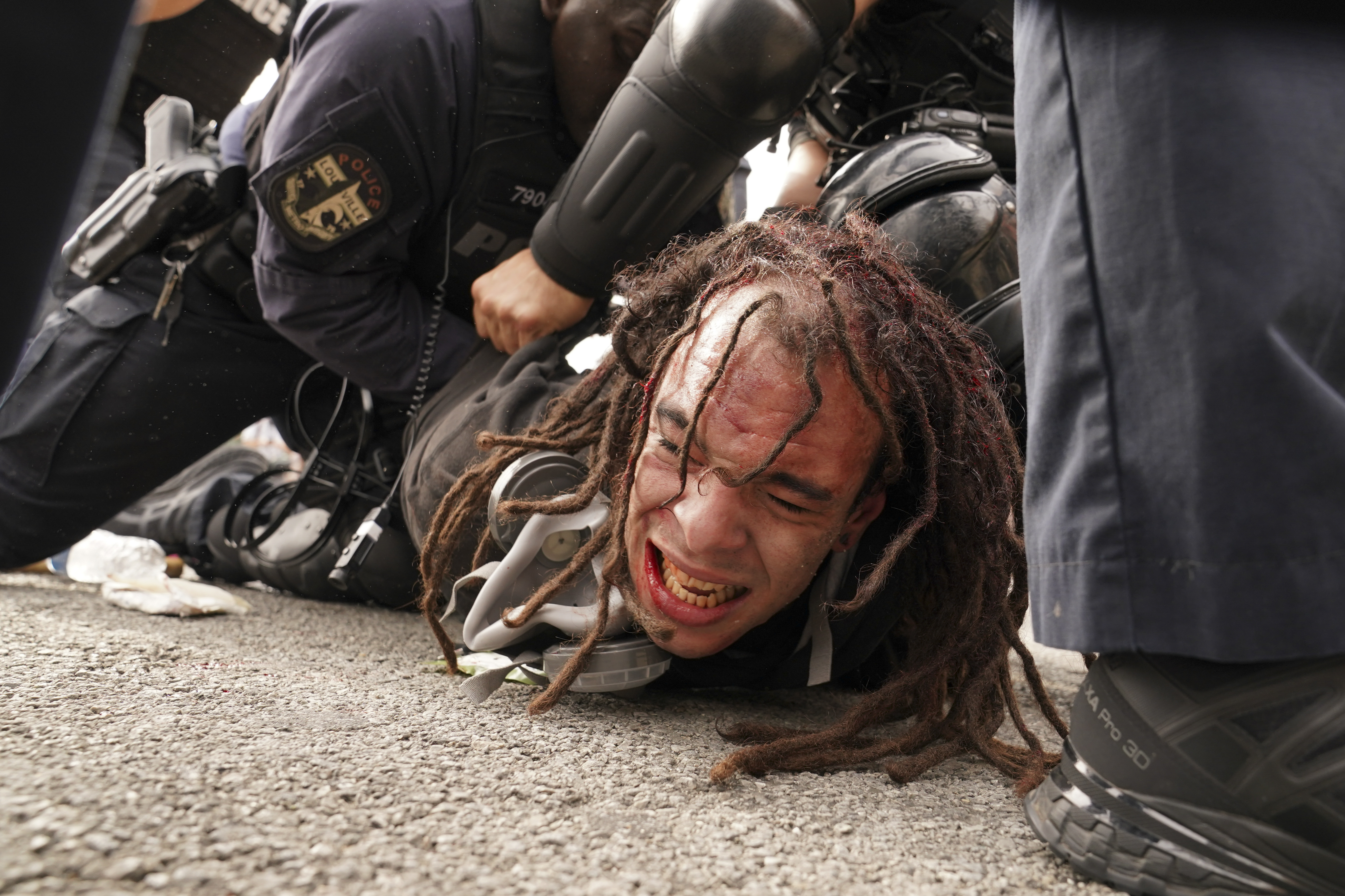 Louisville police detain a man after a group marched, Wednesday, Sept. 23, 2020, in Louisville, Ky. A grand jury has indicted one officer on criminal charges six months after Breonna Taylor was fatally shot by police in Kentucky. The jury presented its decision against fired officer Brett Hankison Wednesday to a judge in Louisville, where the shooting took place. (AP Photo/John Minchillo)