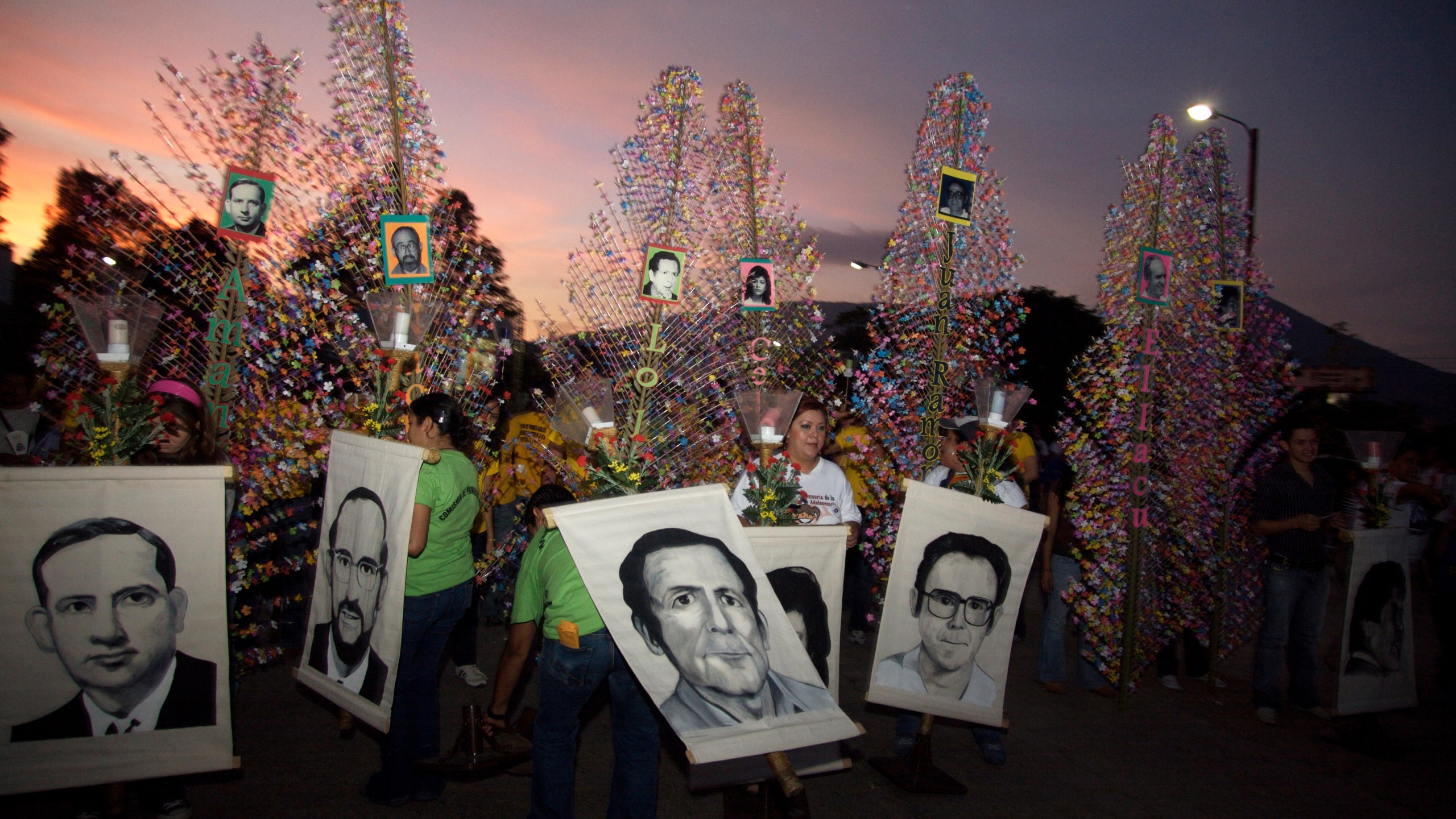 In this Nov. 15, 2008 file photo, people hold banners depicting six Jesuit priests massacred in 1989, during a memorial to mark the 19th anniversary of their death, in San Salvador. For years, attempts within El Salvador to investigate and prosecute the masterminds of the massacre during that country’s civil war have been delayed and deflected by legal maneuvers. (Edgar Romero/AP Photo File)