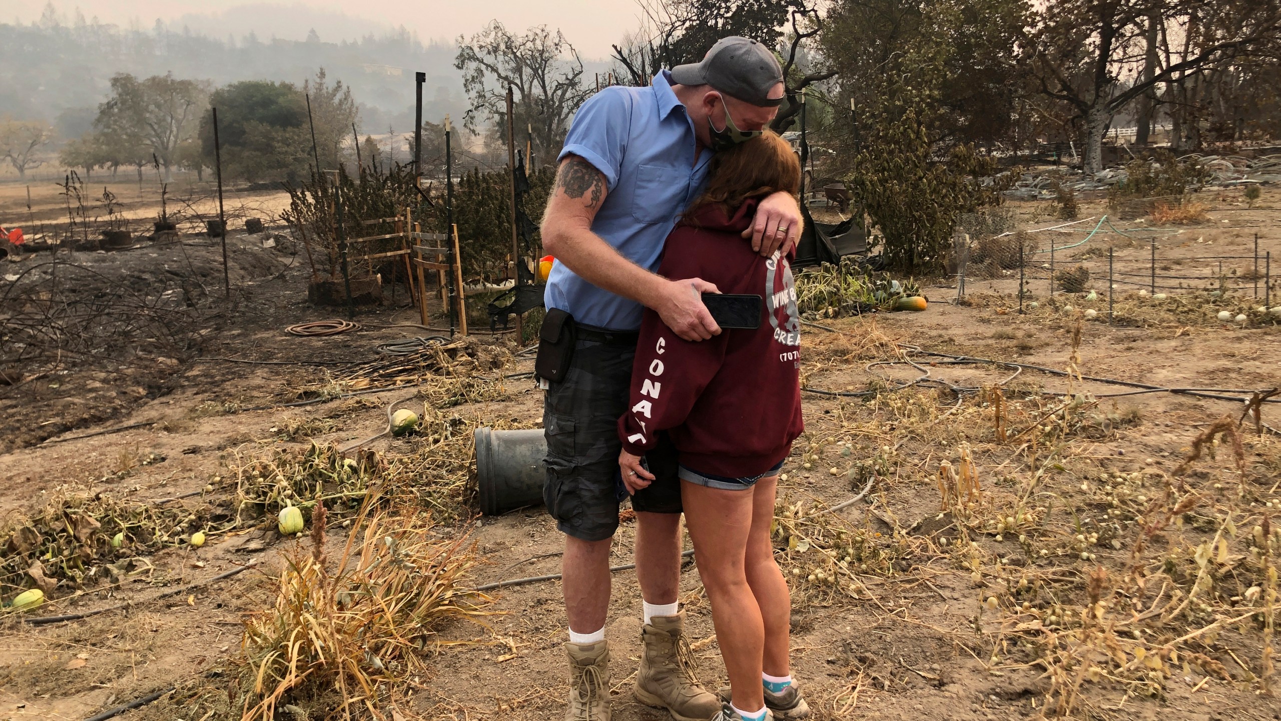 Kevin Conant and his wife, Nikki, hug after looking at the debris of their burnt Santa Rosa home and business "Conants Wine Barrel Creations" on Sept. 30, 2020, after the Glass/Shady fire completely engulfed it. (Haven Daley / Associated Press)