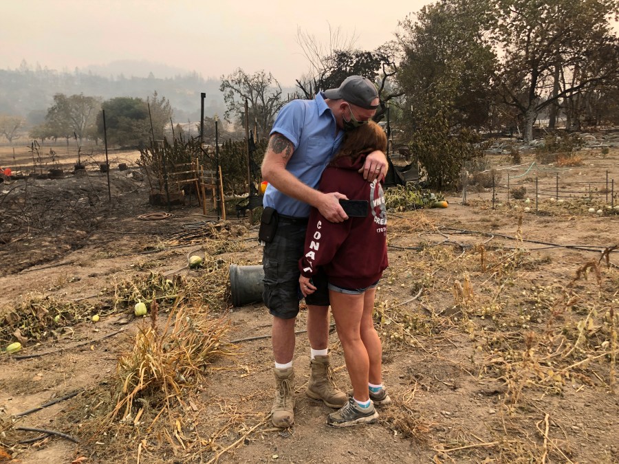 Kevin Conant and his wife, Nikki, hug after looking at the debris of their burnt Santa Rosa home and business "Conants Wine Barrel Creations" on Sept. 30, 2020, after the Glass/Shady fire completely engulfed it. (Haven Daley / Associated Press)