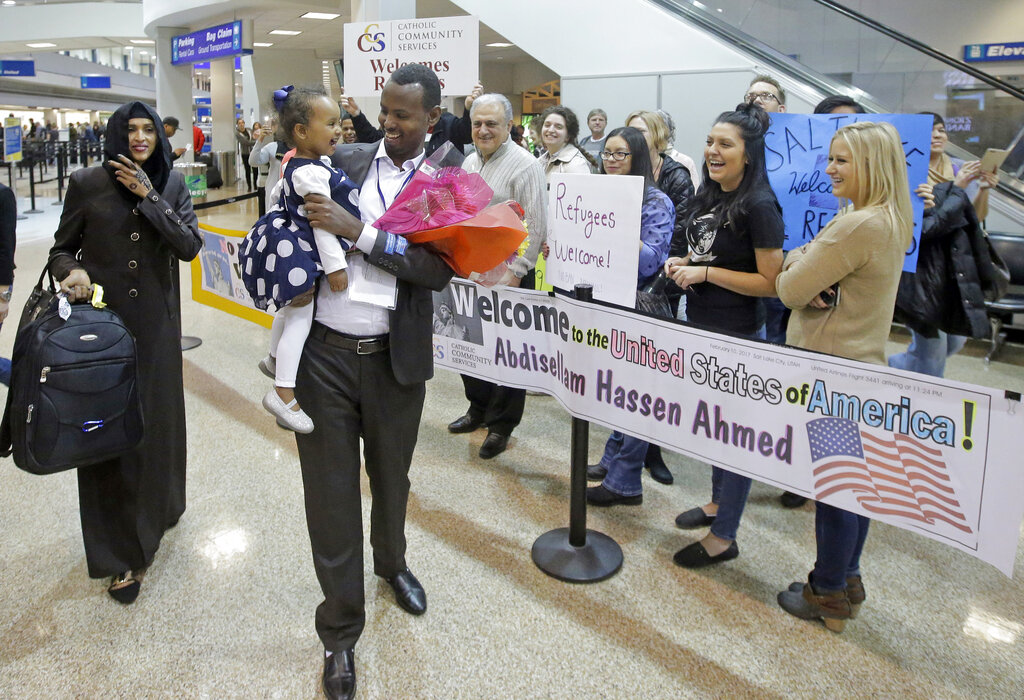 Abdisellam Hassen Ahmed, a Somali refugee who had been stuck in limbo after President Donald Trump temporarily banned refugee entries, walks with his wife Nimo Hashi, and his 2-year-old daughter, Taslim, who he met for the first time after arriving at Salt Lake City International Airport on Feb. 10, 2017. (AP Photo/Rick Bowmer, File)