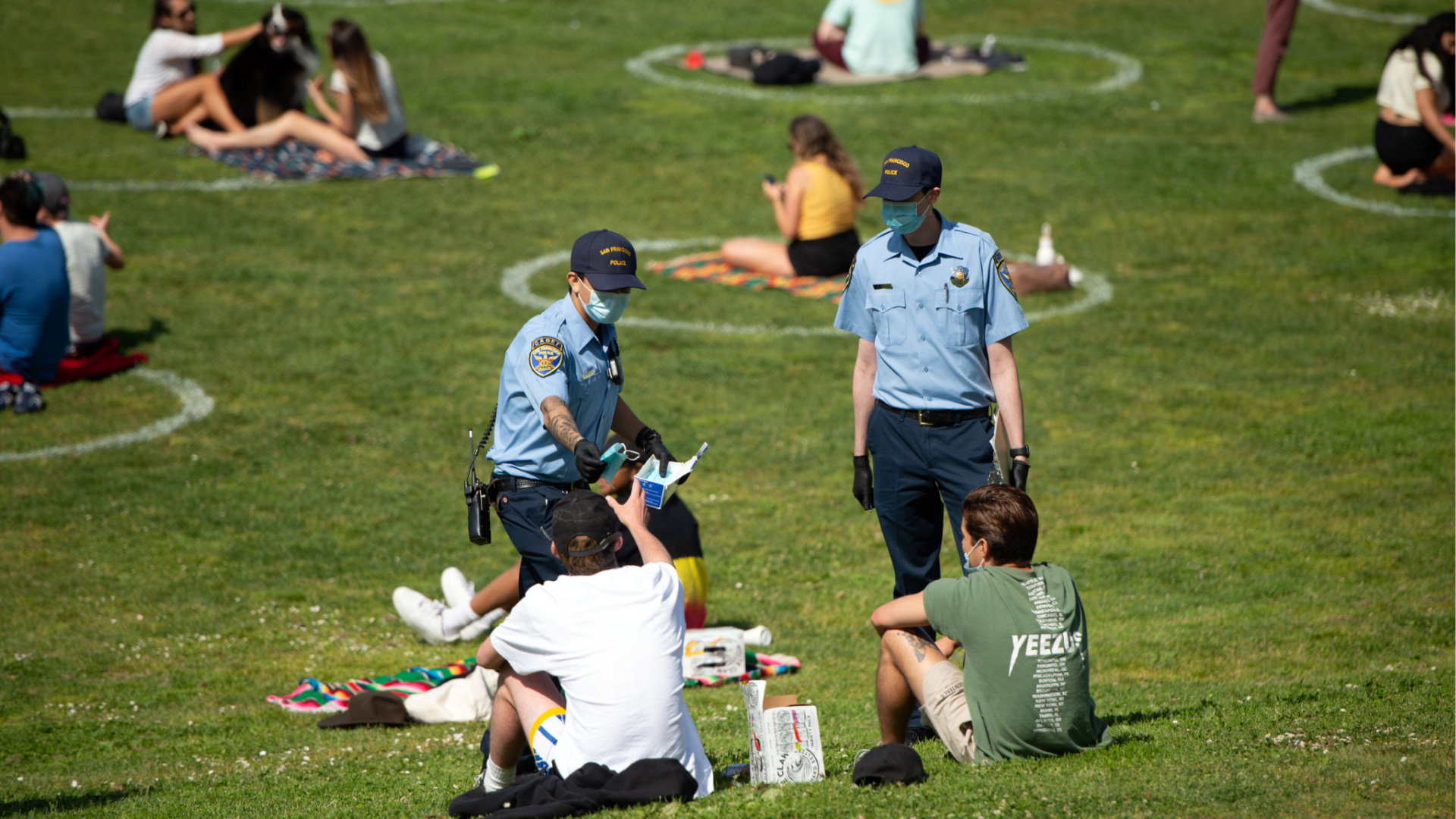 San Francisco police officer cadets distribute face masks to people at Dolores Park in San Francisco, California on May 22, 2020. (Josh Edelson /AFP via Getty Images)